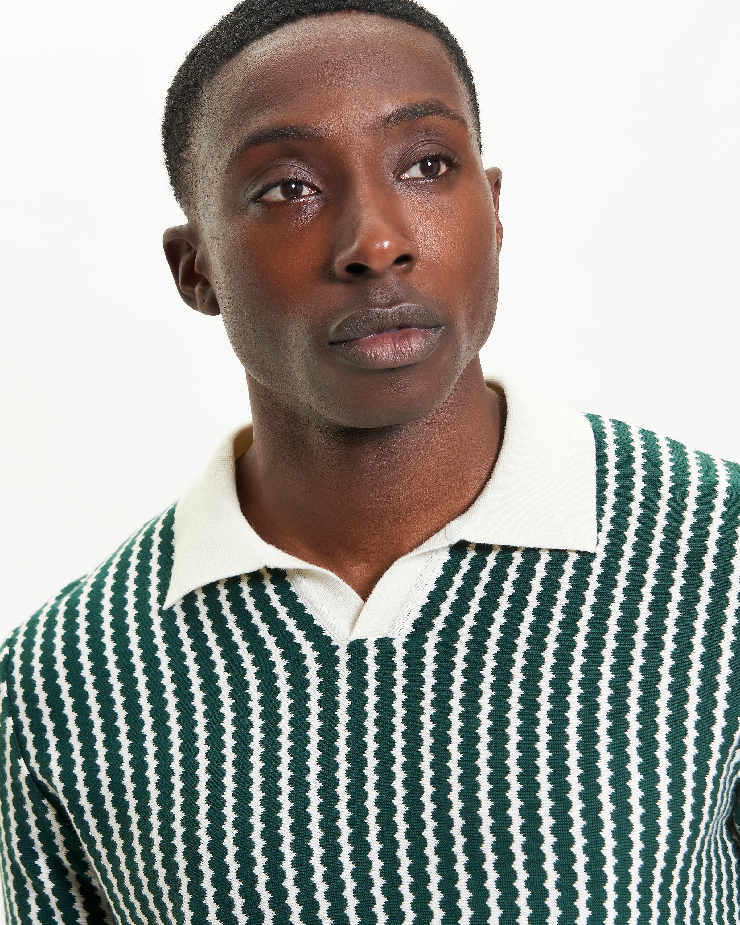 Vertical Wave Polo – green and white vertical wave pattern, relaxed fit with open neckline, model wearing polo shirt.