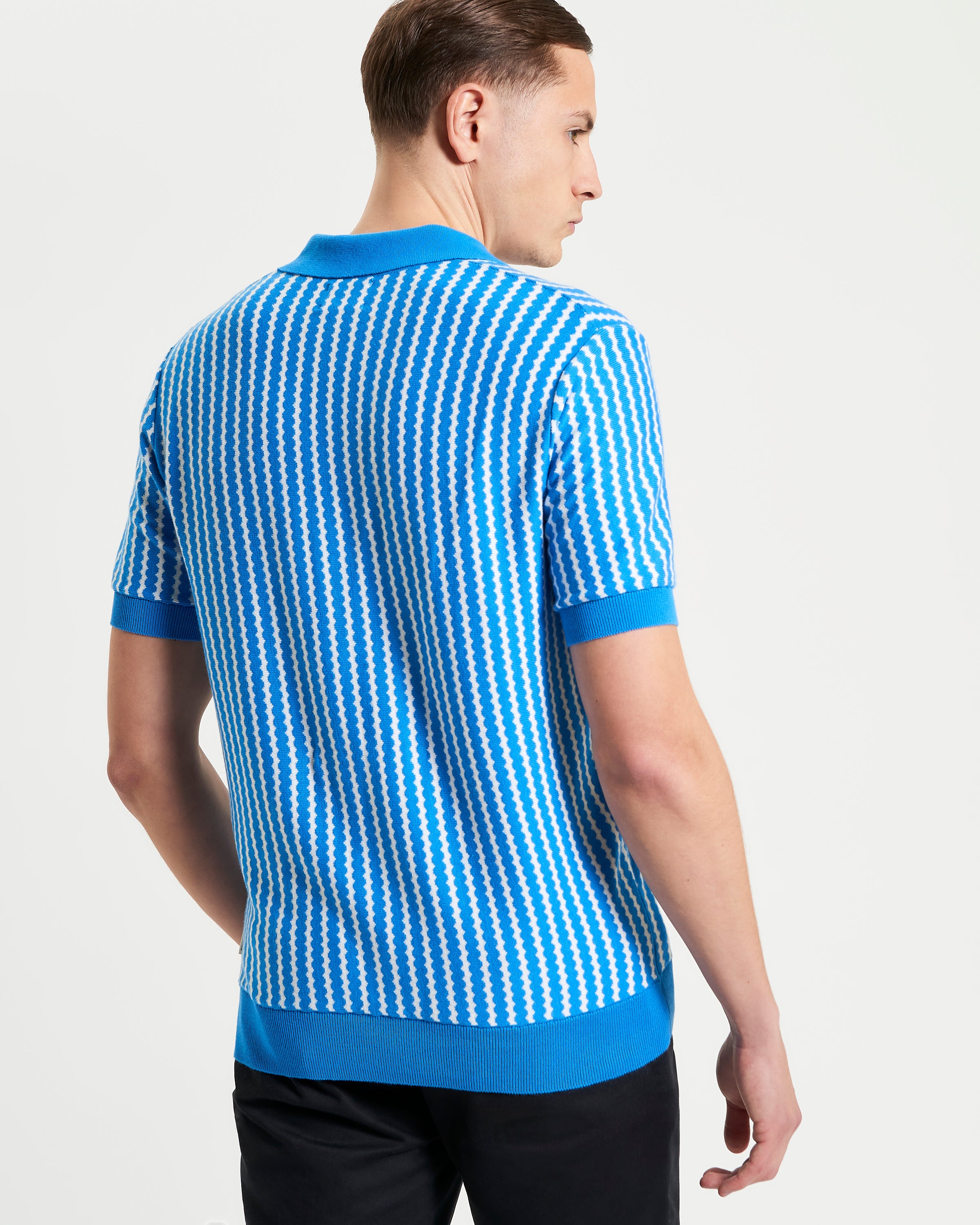 Vertical Wave Polo – Blue knitted polo shirt with vertical wave pattern, showcasing relaxed fit and open neckline.