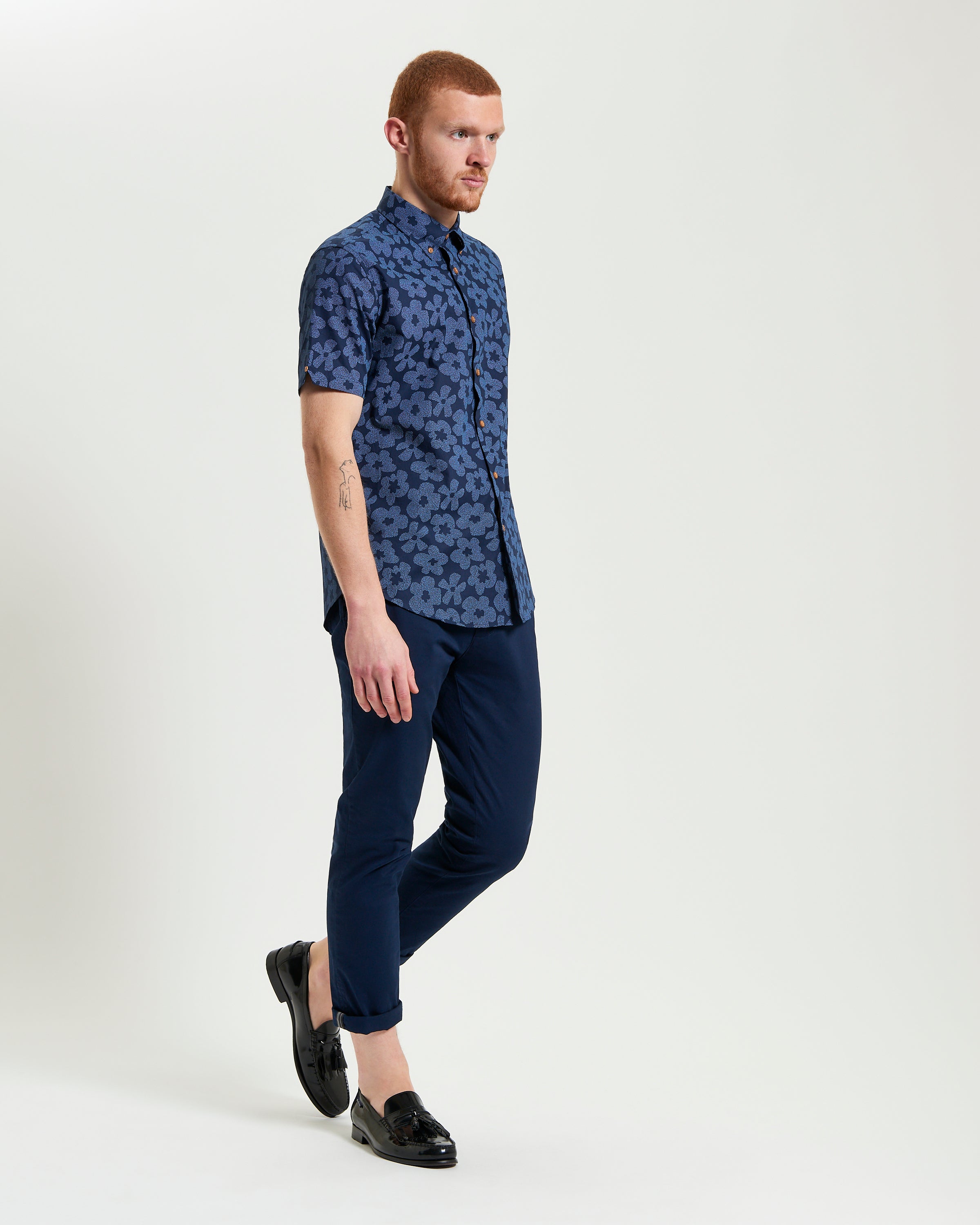 Stipple Floral Print – a man wearing a navy floral shirt paired with tailored pants and black loafers.