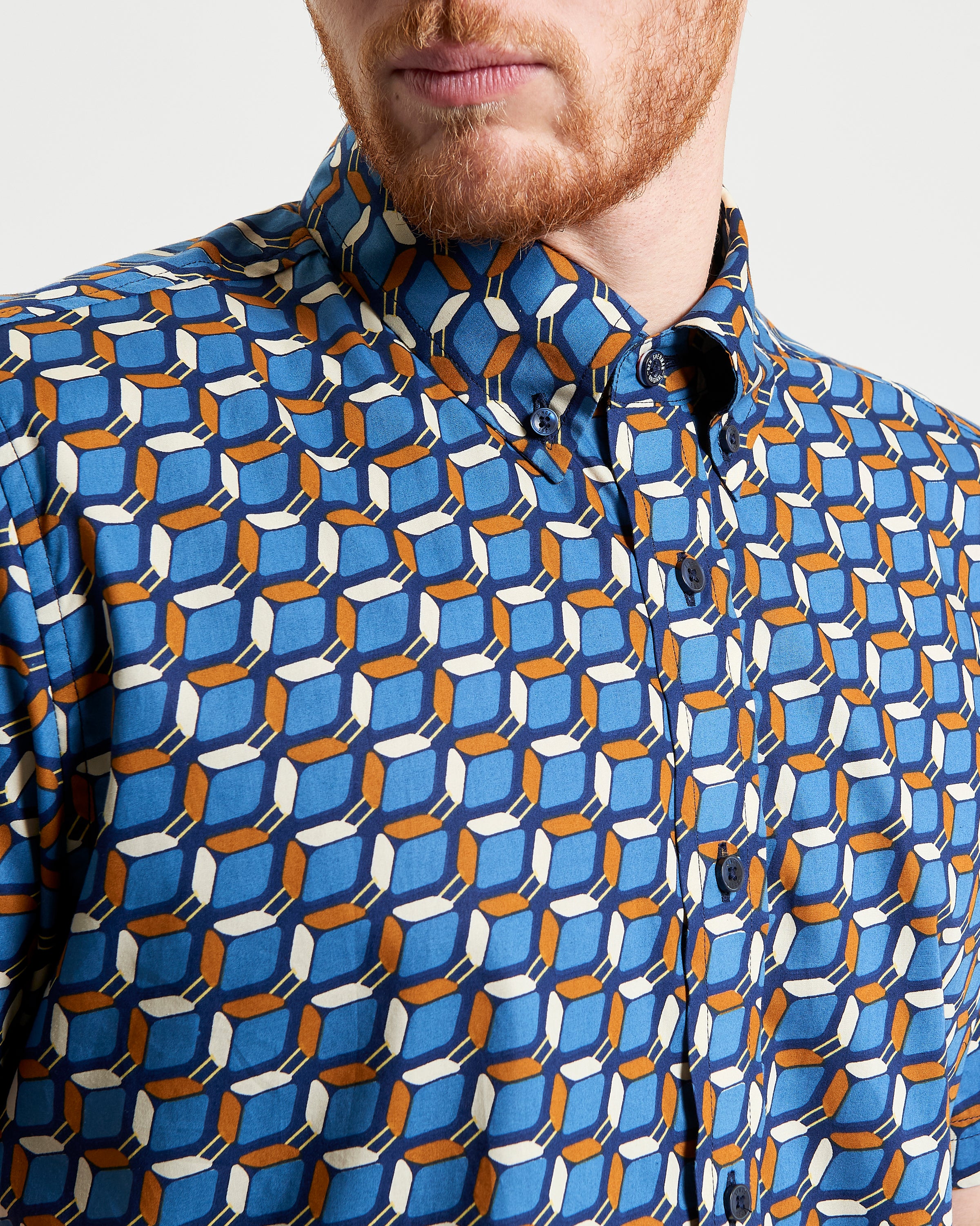 Retro Geo Print shirt featuring a bold vintage-inspired geo pattern in blue, orange, and white.