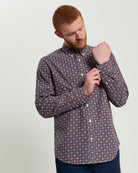 Man adjusting sleeves of Block Foulard Print long-sleeve shirt, perfect for smart-casual and office settings.