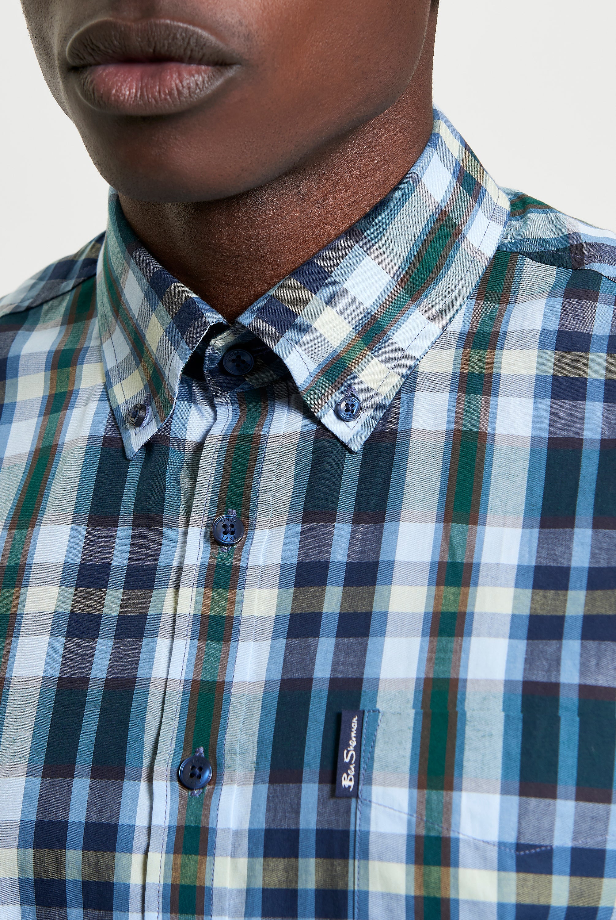 Irregular Check shirt featuring curved hem and button-down collar, perfect for a modern casual wardrobe.
