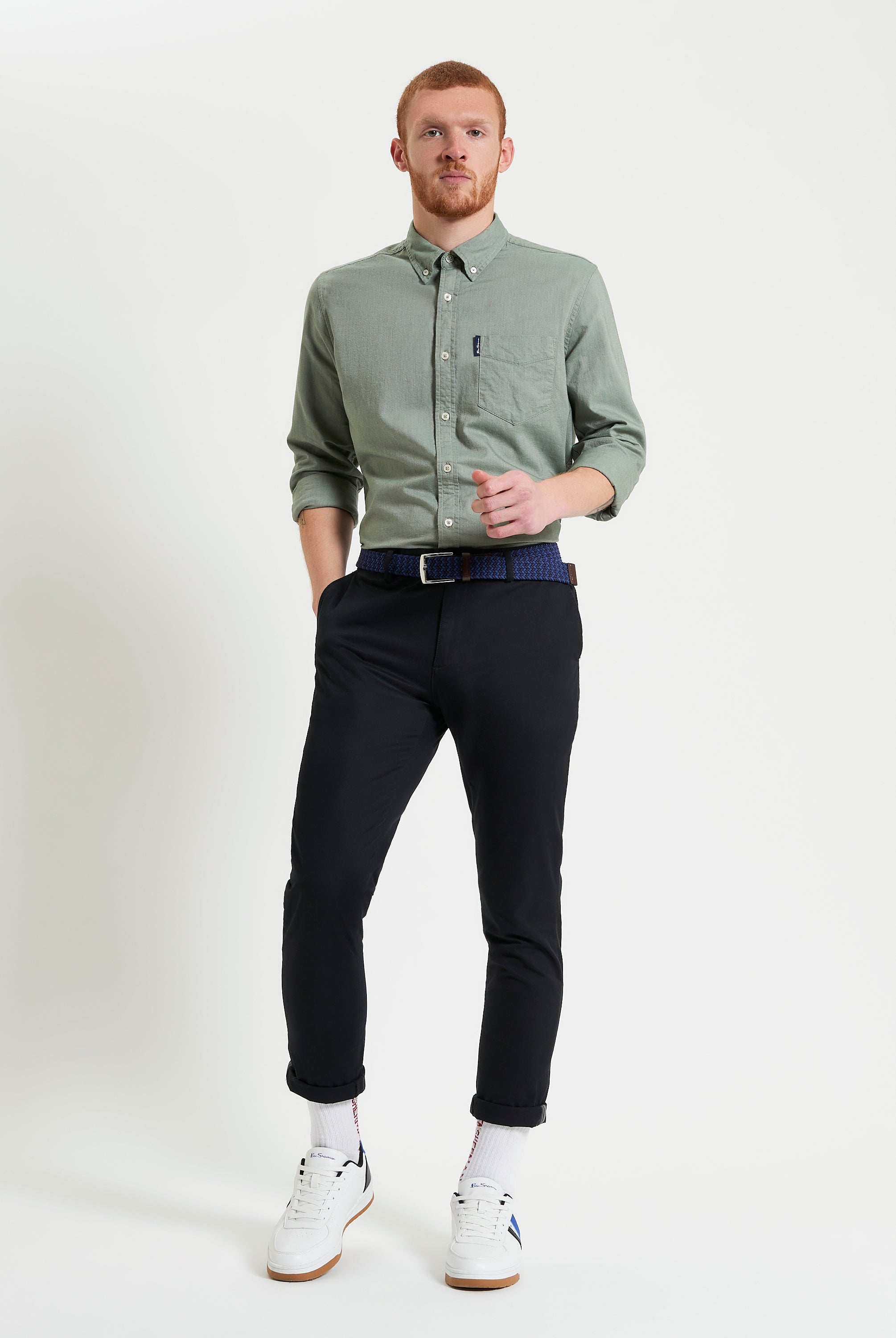 Man wearing a Signature Oxford Long Sleeve Shirt by Ben Sherman, styled with black pants and white sneakers.