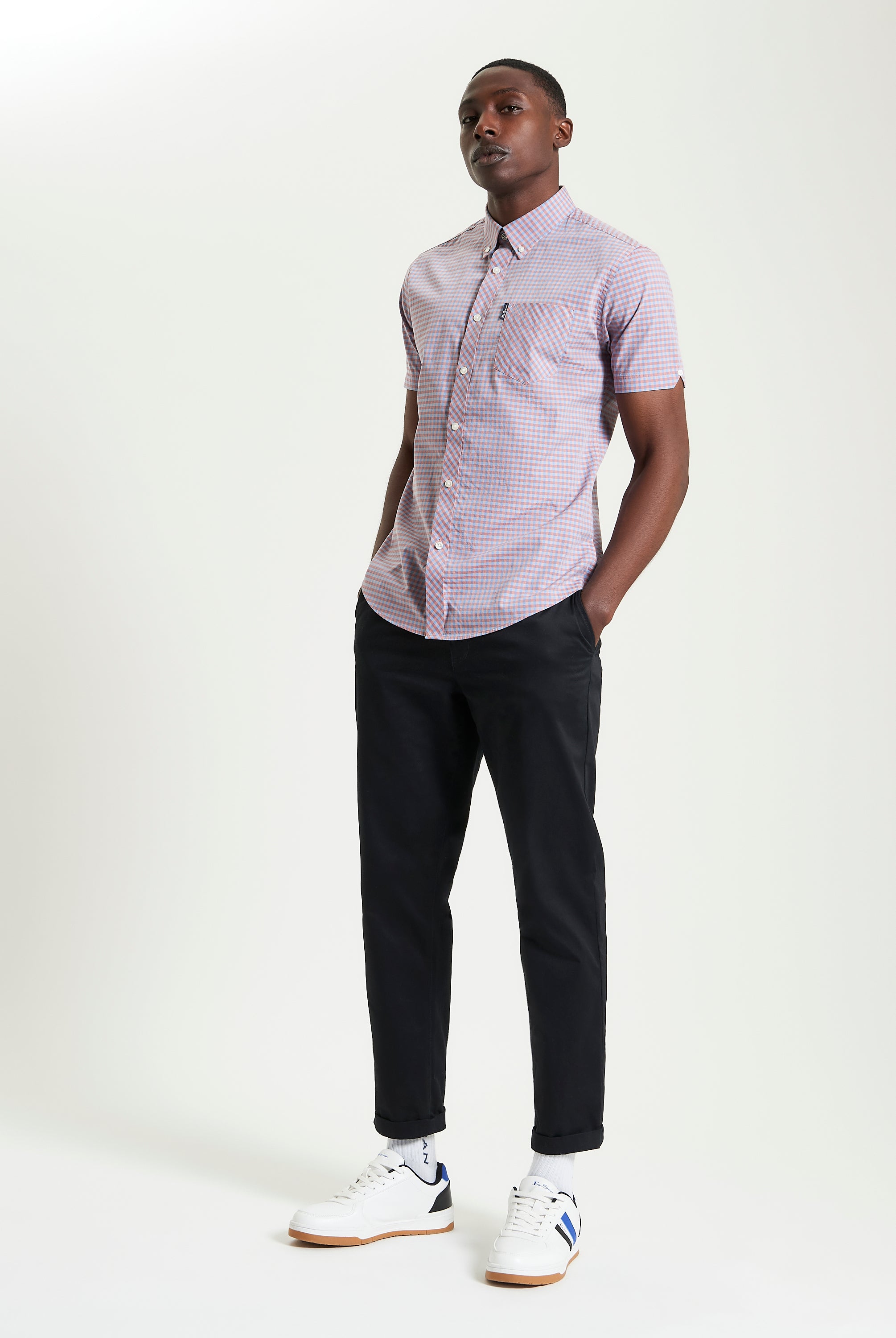 Model wearing Signature Gingham Short Sleeve Shirt with black pants and sneakers.