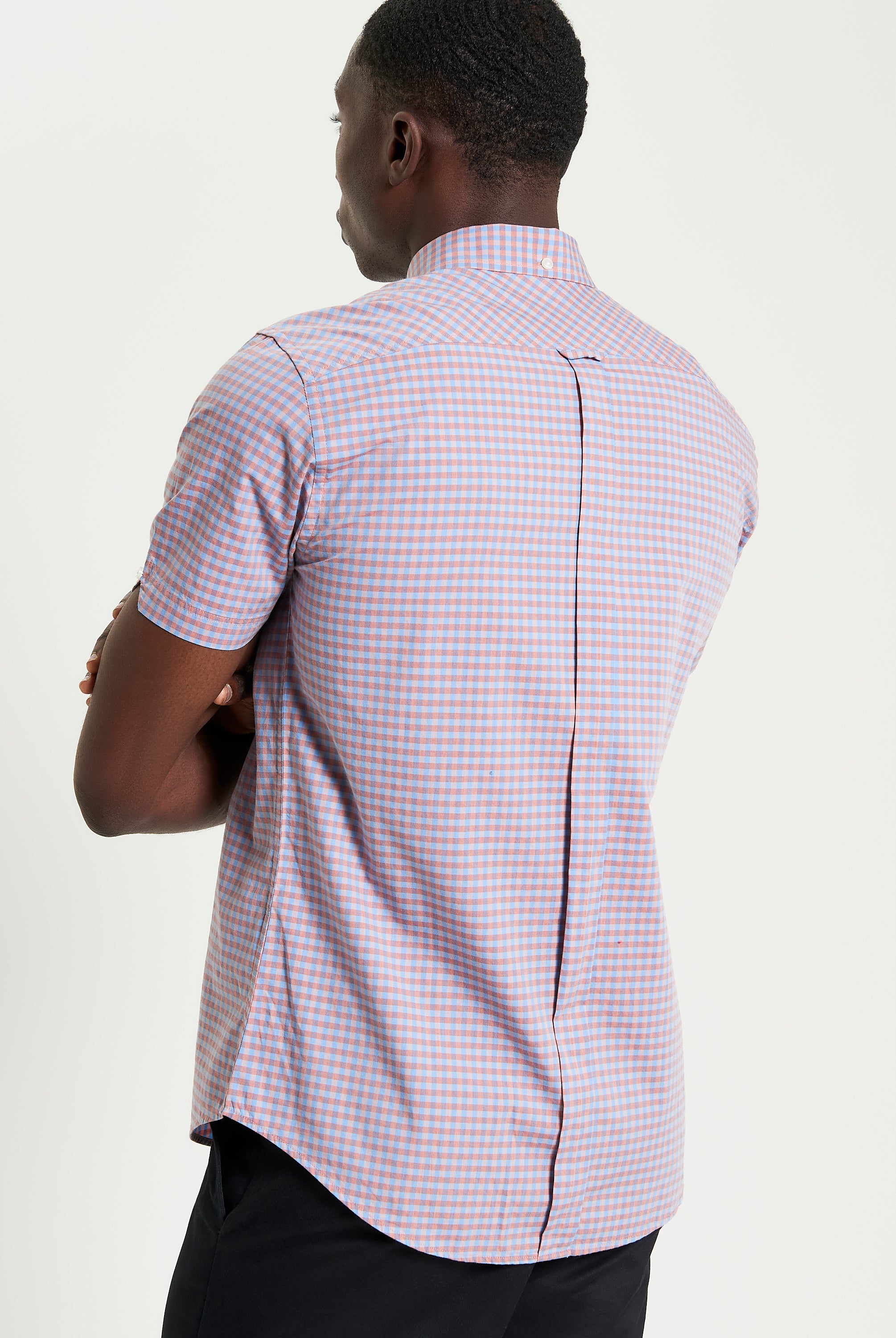 Man wearing a Signature Gingham Short Sleeve Shirt with a two-finger button-down collar and back box pleat for comfort.