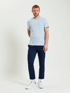 Signature Tee – light blue crew neck with branded silicon badge, styled with navy pants, ideal for casual wear.