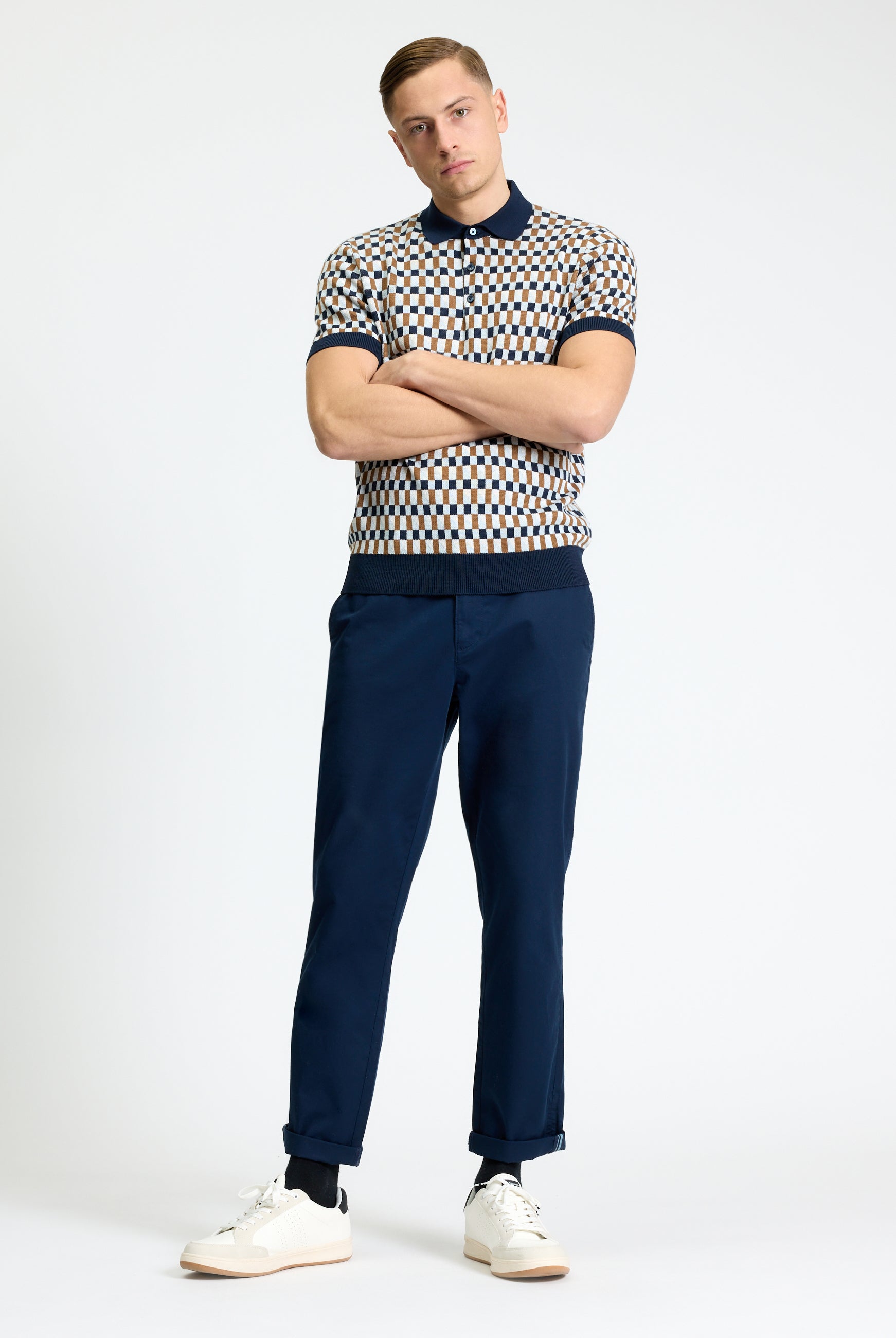 All Over Jacquard Polo – Stylish man wearing a jacquard polo shirt with navy trousers and sneakers.