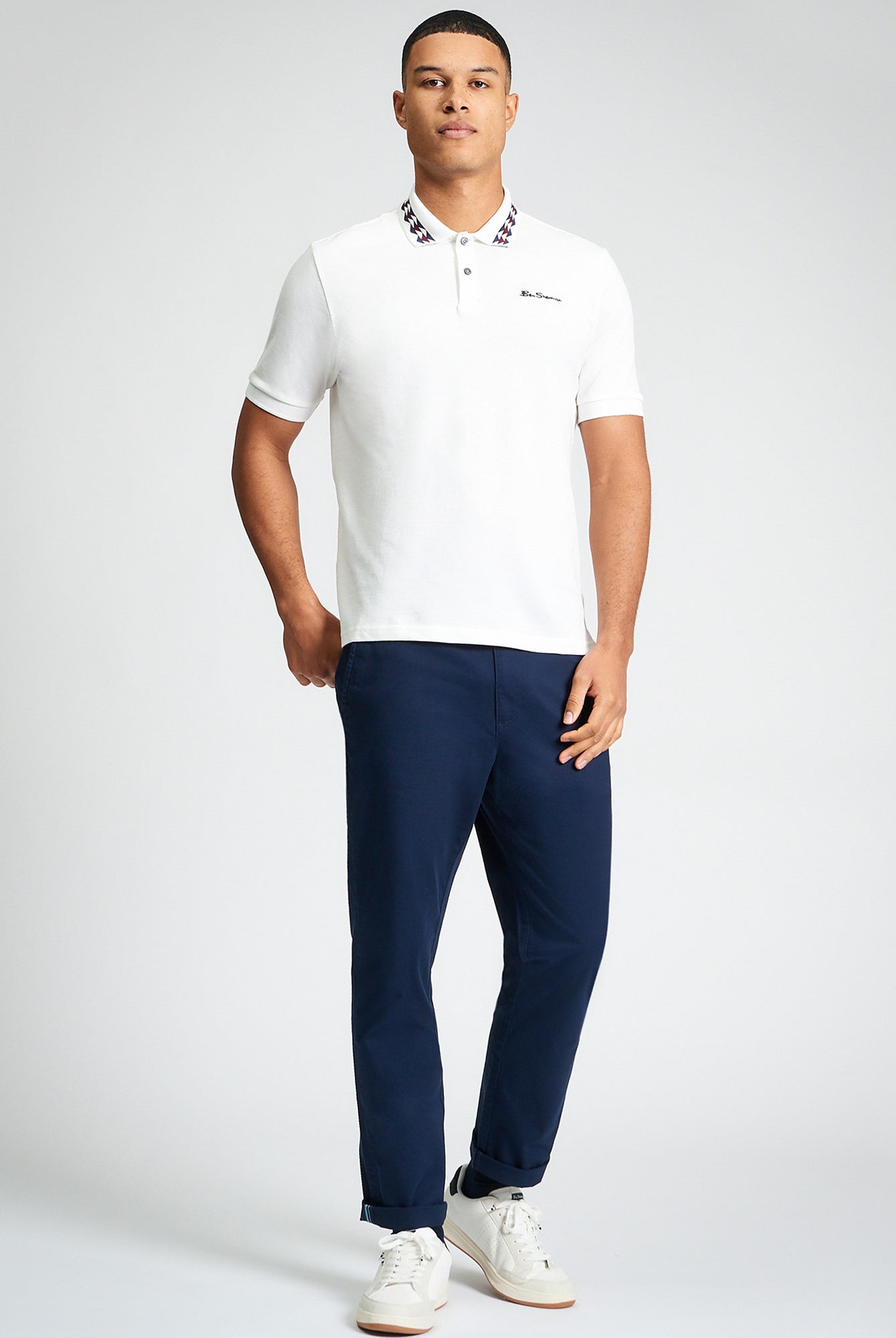 Collar Interest Polo β white β featuring patterned collar detail and Ben Sherman embroidery, worn with navy pants.