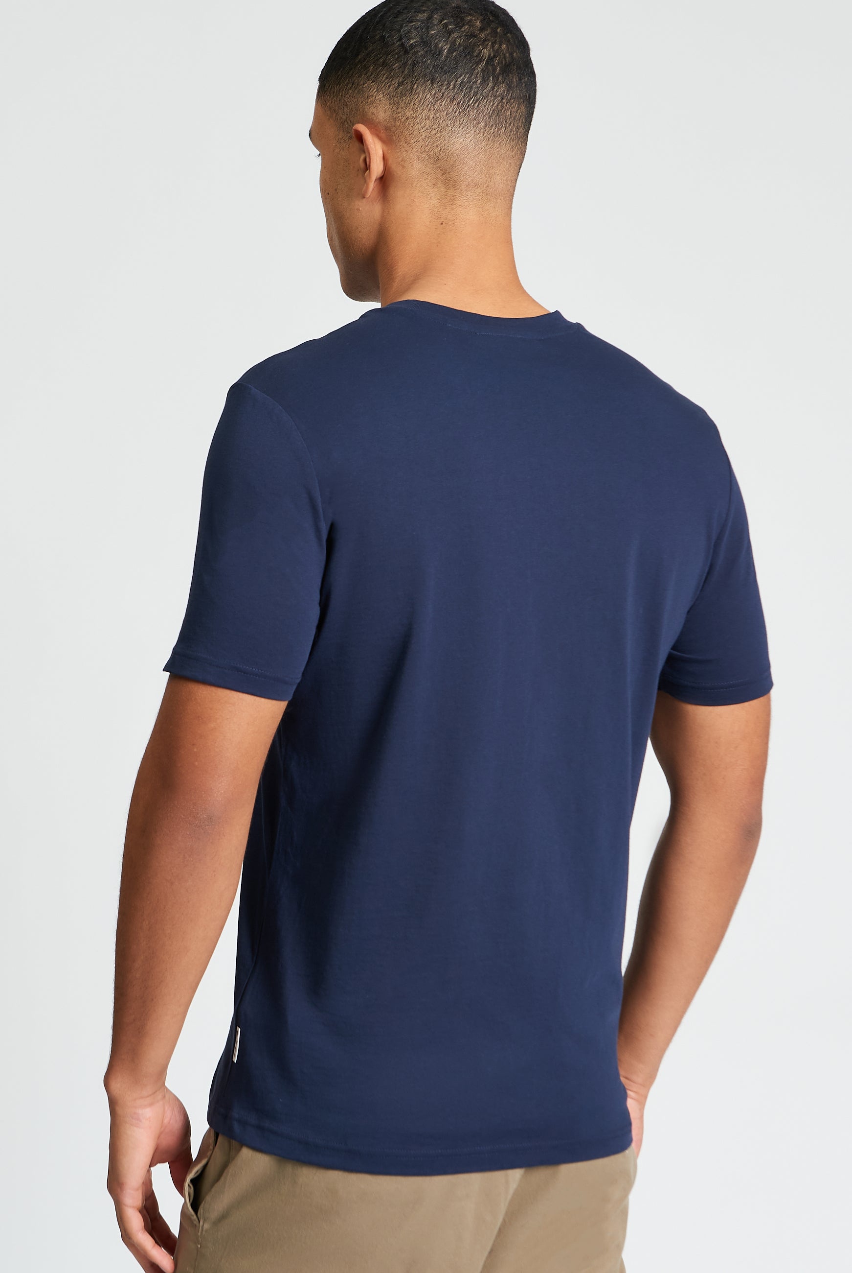 Plectrum Target Tee back view, showcasing the navy blue organic cotton fabric and signature branding detail.