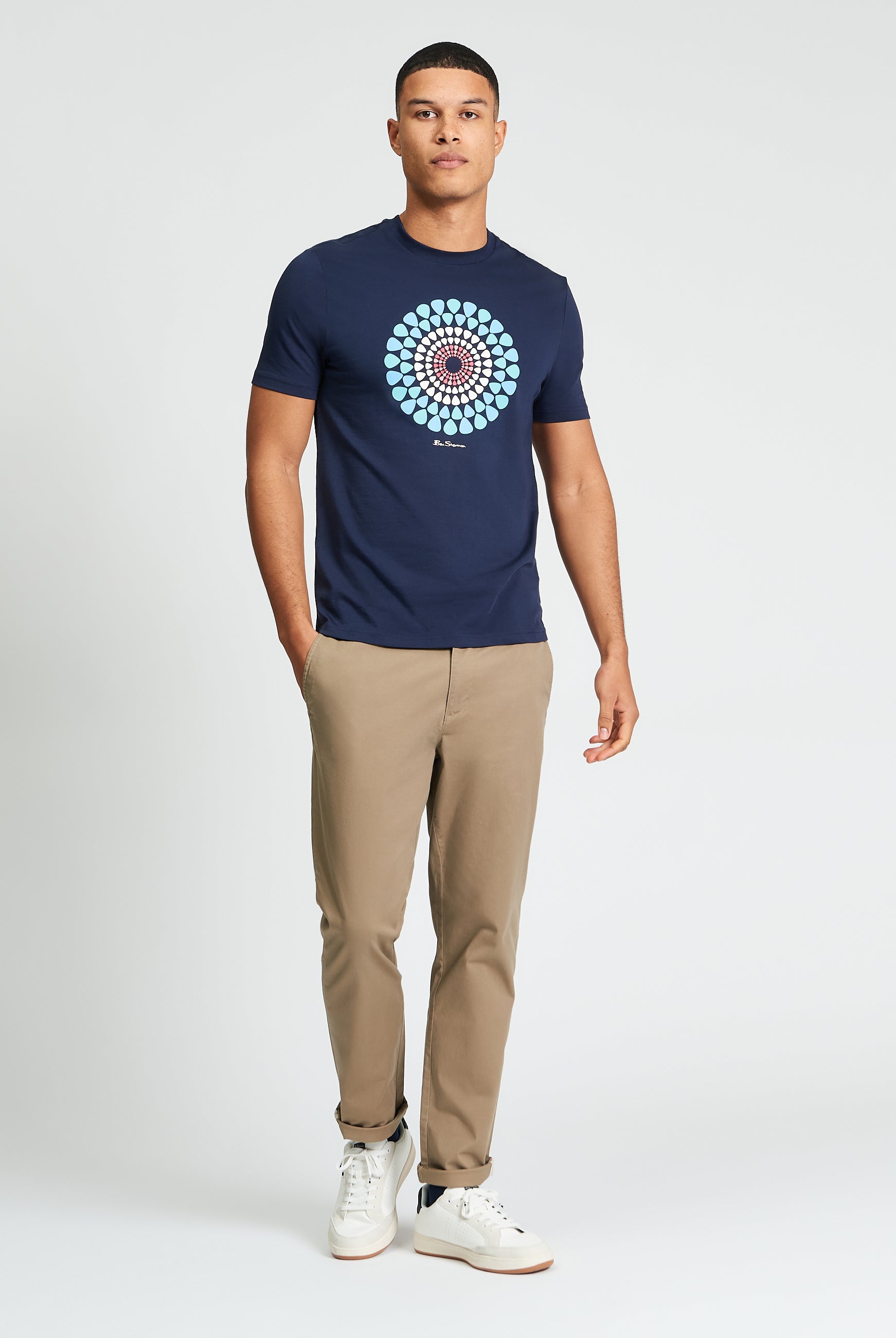 Man wearing Plectrum Target Tee by Ben Sherman with target graphic, paired with chinos and sneakers.