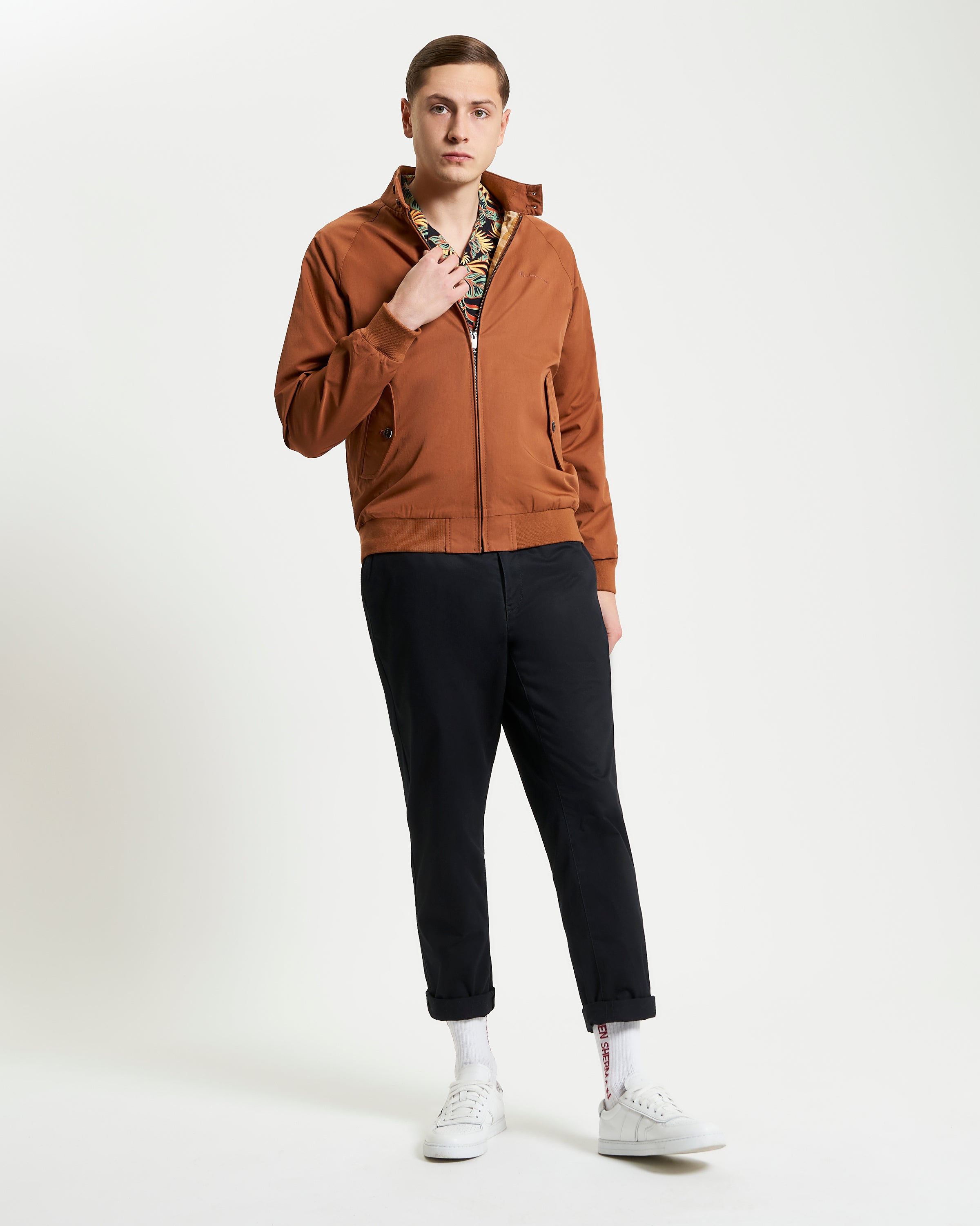 Model wearing Signature Harrington Jacket with brown zip-up design and stylish pants, showcasing contemporary British fashion.