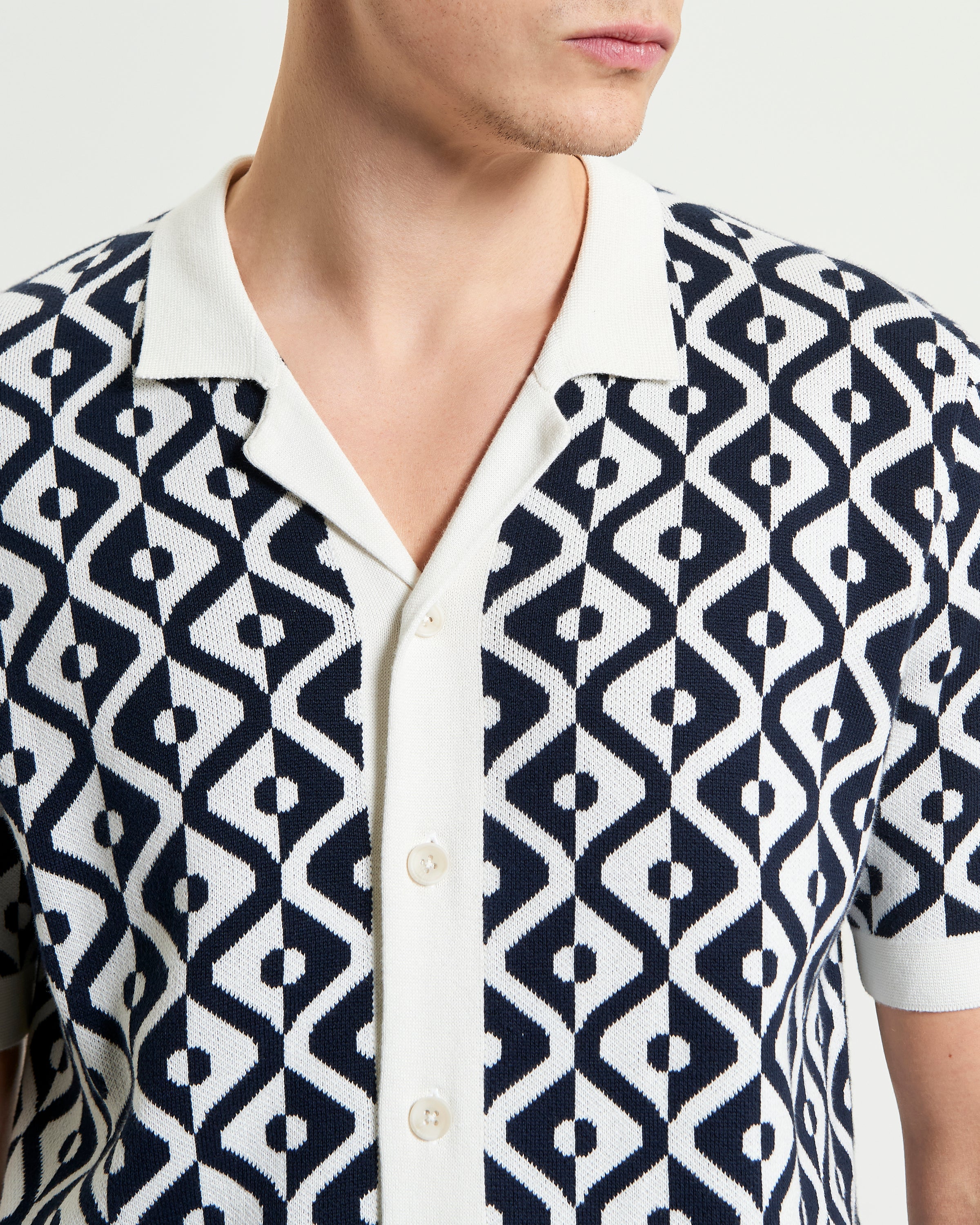 Model wearing the Tile Resort Knitted Shirt featuring a tile jacquard knit in navy and white.