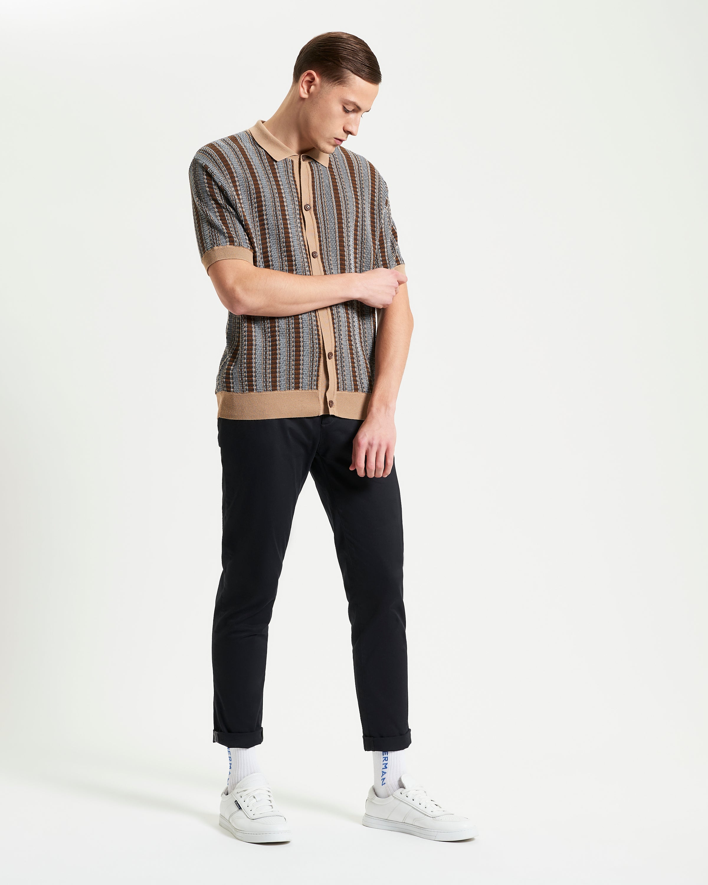 Textured Stripe Knitted Shirt – beige and brown striped button-through shirt paired with black pants and white sneakers.