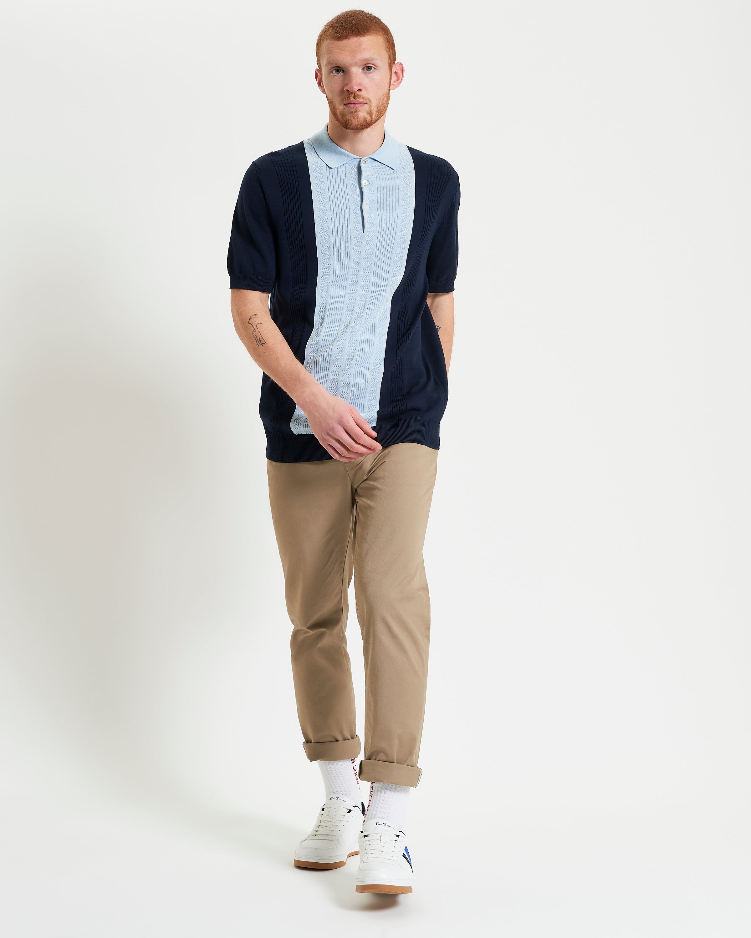 Textured Block Stripe Polo – navy and light blue short sleeve polo worn by man with beige pants and white sneakers.