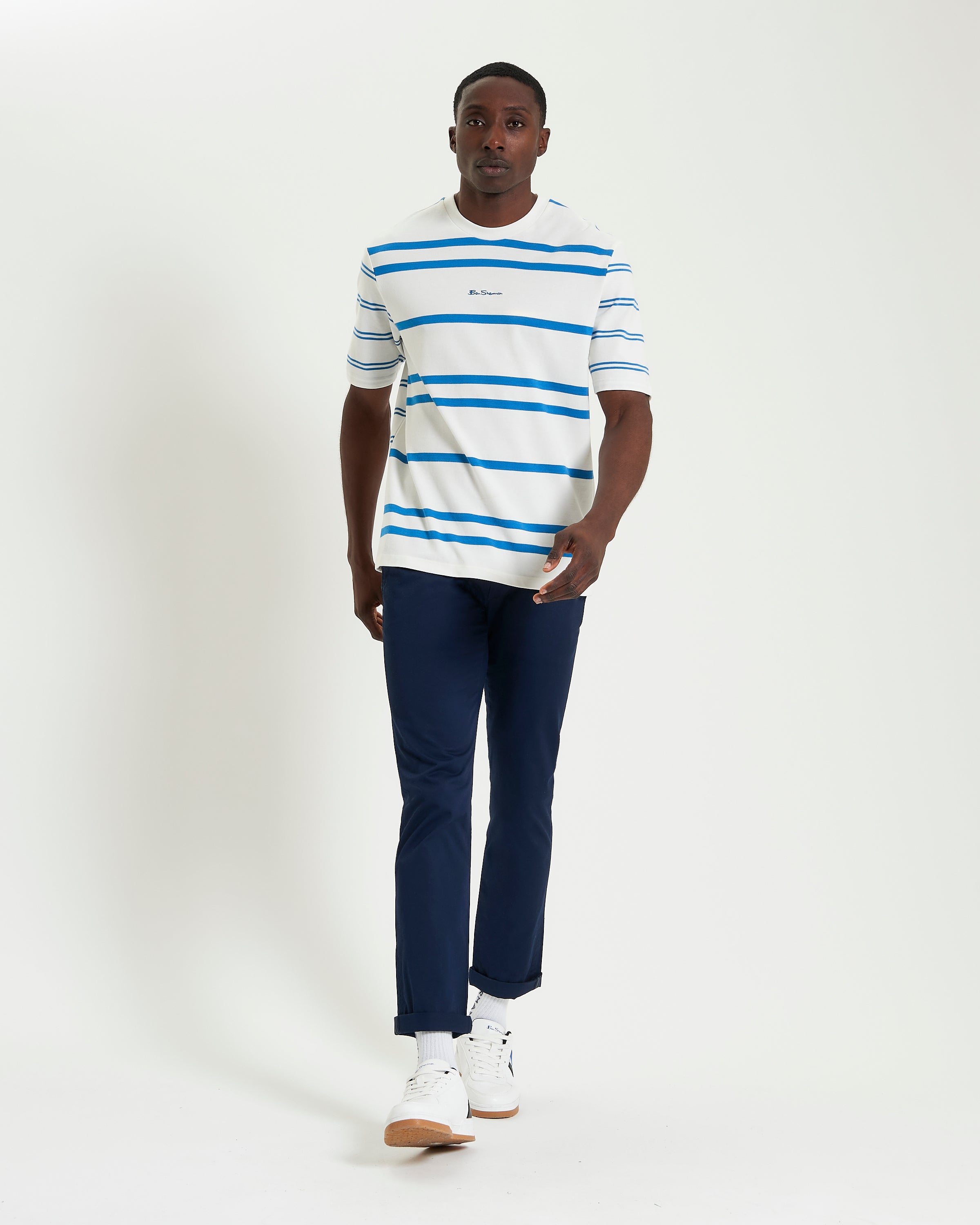 Mixed Stripe Tee – blue and white striped shirt worn with navy pants, model walking forward.