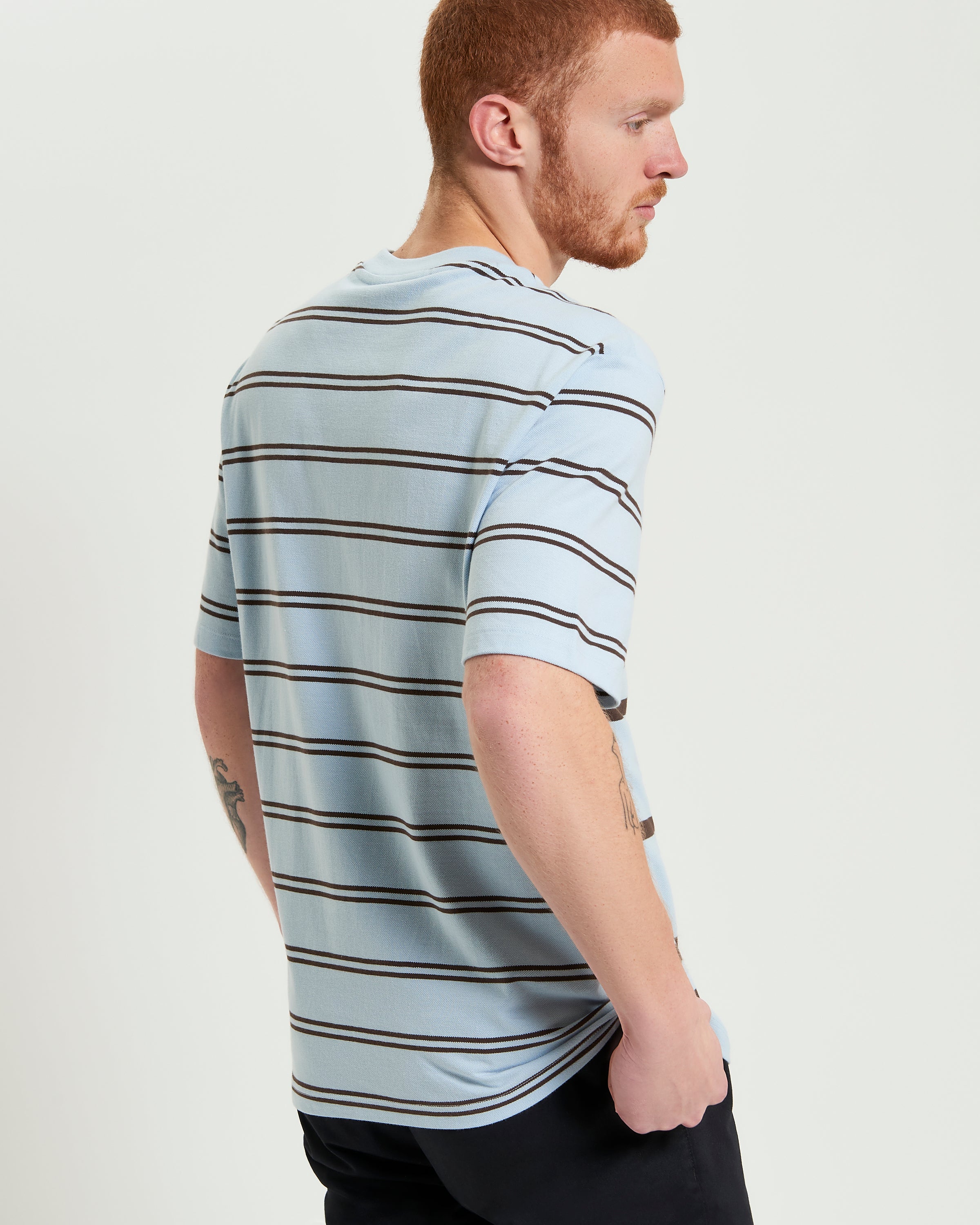 Mixed Stripe Tee – Relaxed fit with mixed stripe design on light blue backdrop.