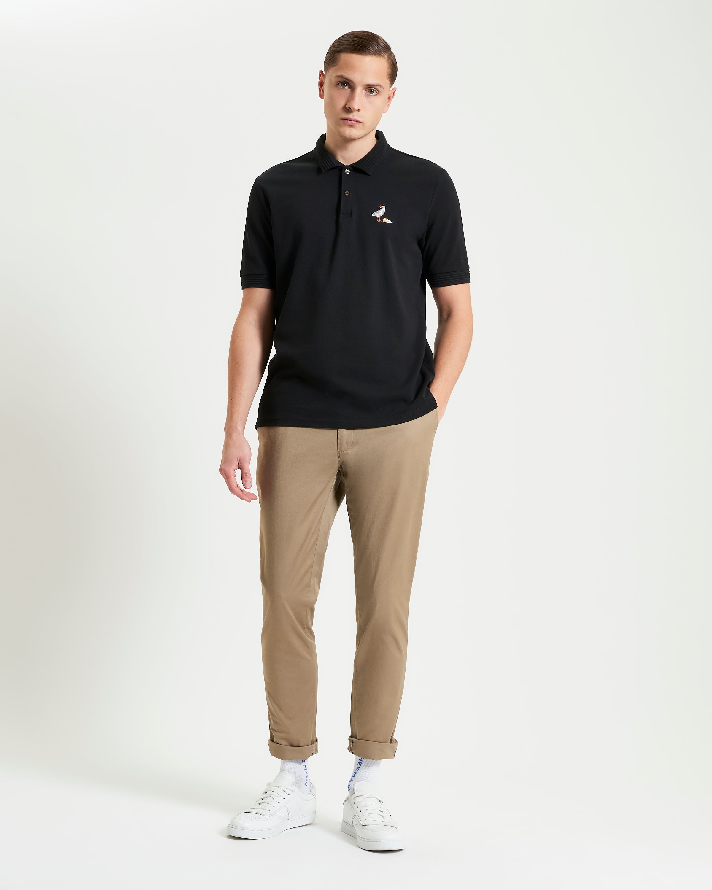 Gull Embroidery Polo – black relaxed fit pique polo with gull embroidery on chest and ribbed collar and cuff.