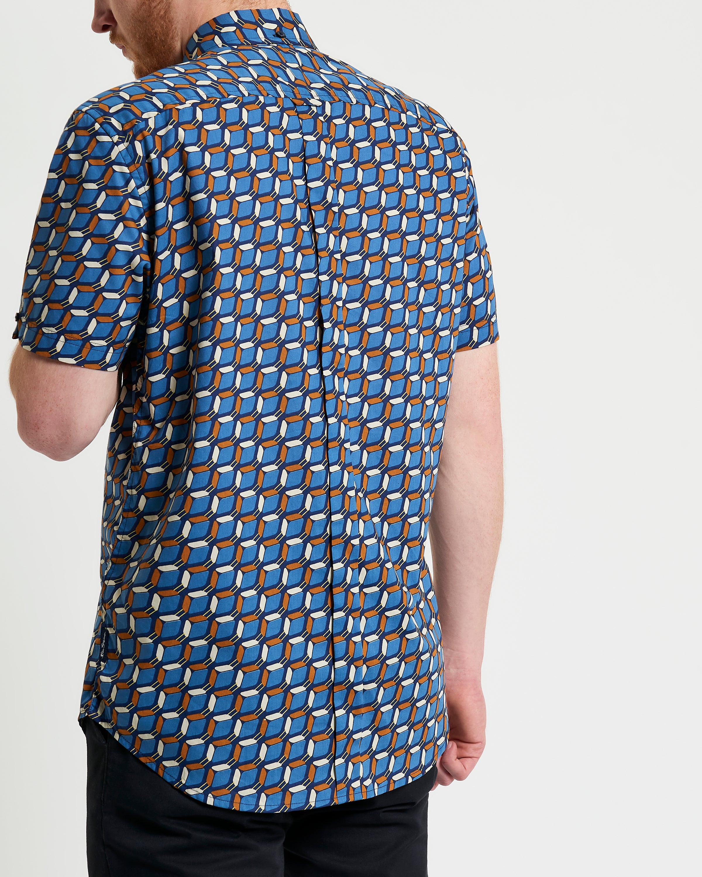 Retro Geo Print shirt showcasing a bold geometric pattern on a blue background, featuring a relaxed fit and unique collar.