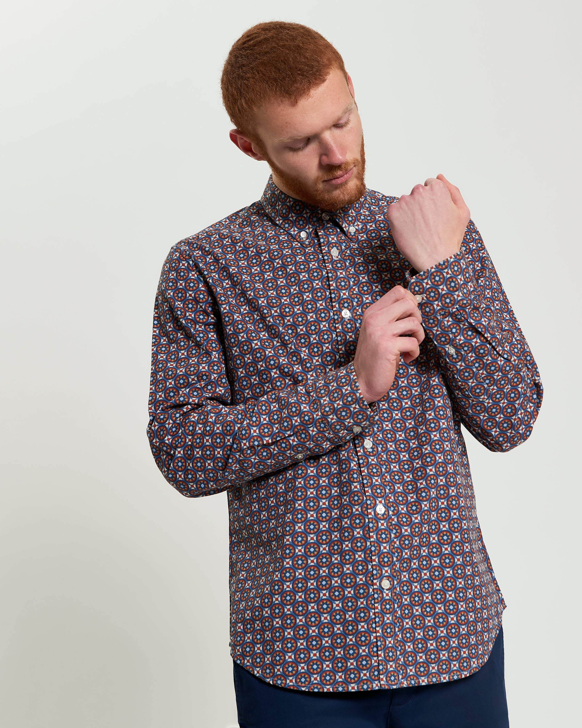 Man adjusting sleeves of Block Foulard Print long-sleeve shirt, perfect for smart-casual and office settings.