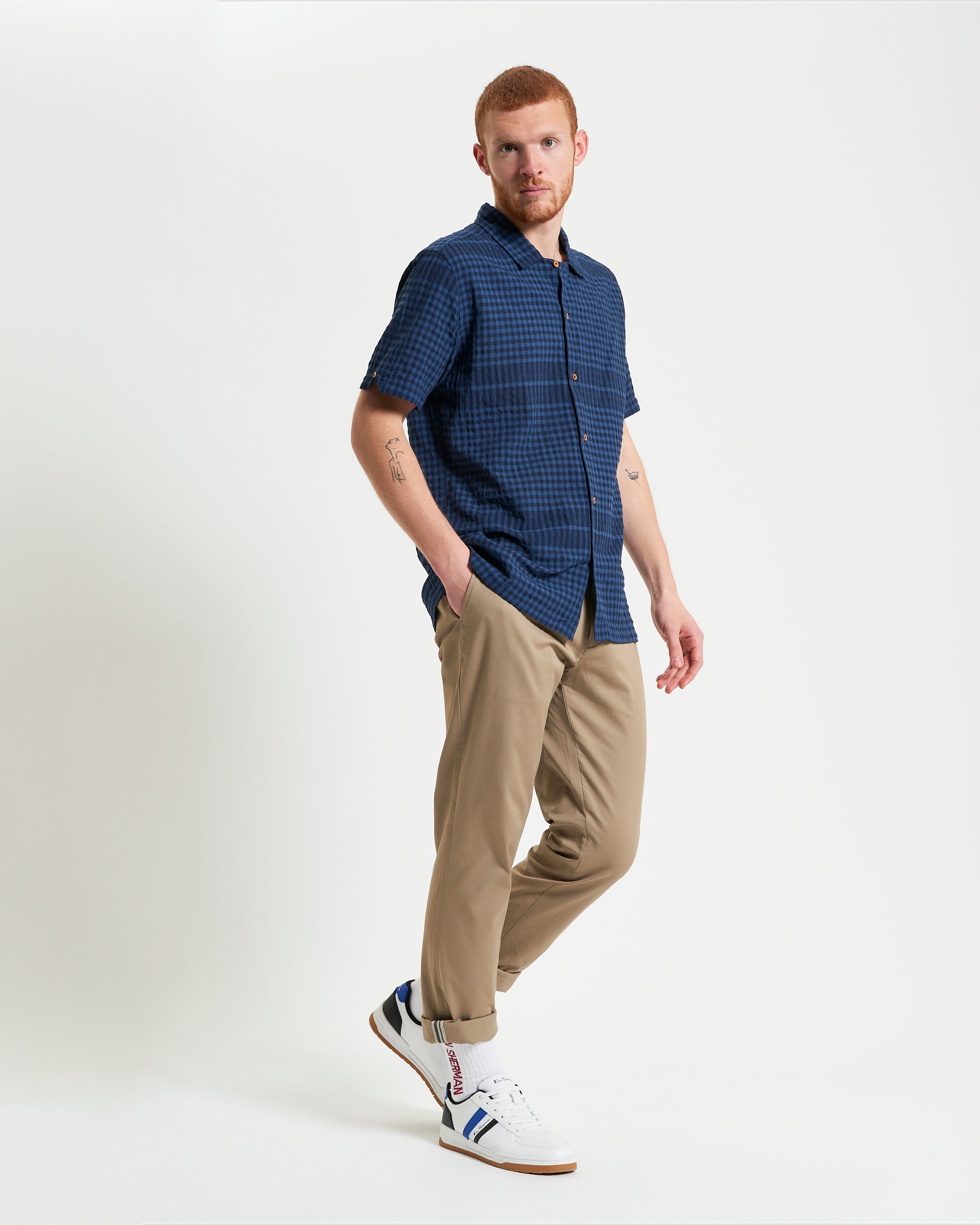 Seersucker Gingham short sleeve shirt worn with beige trousers and sneakers.