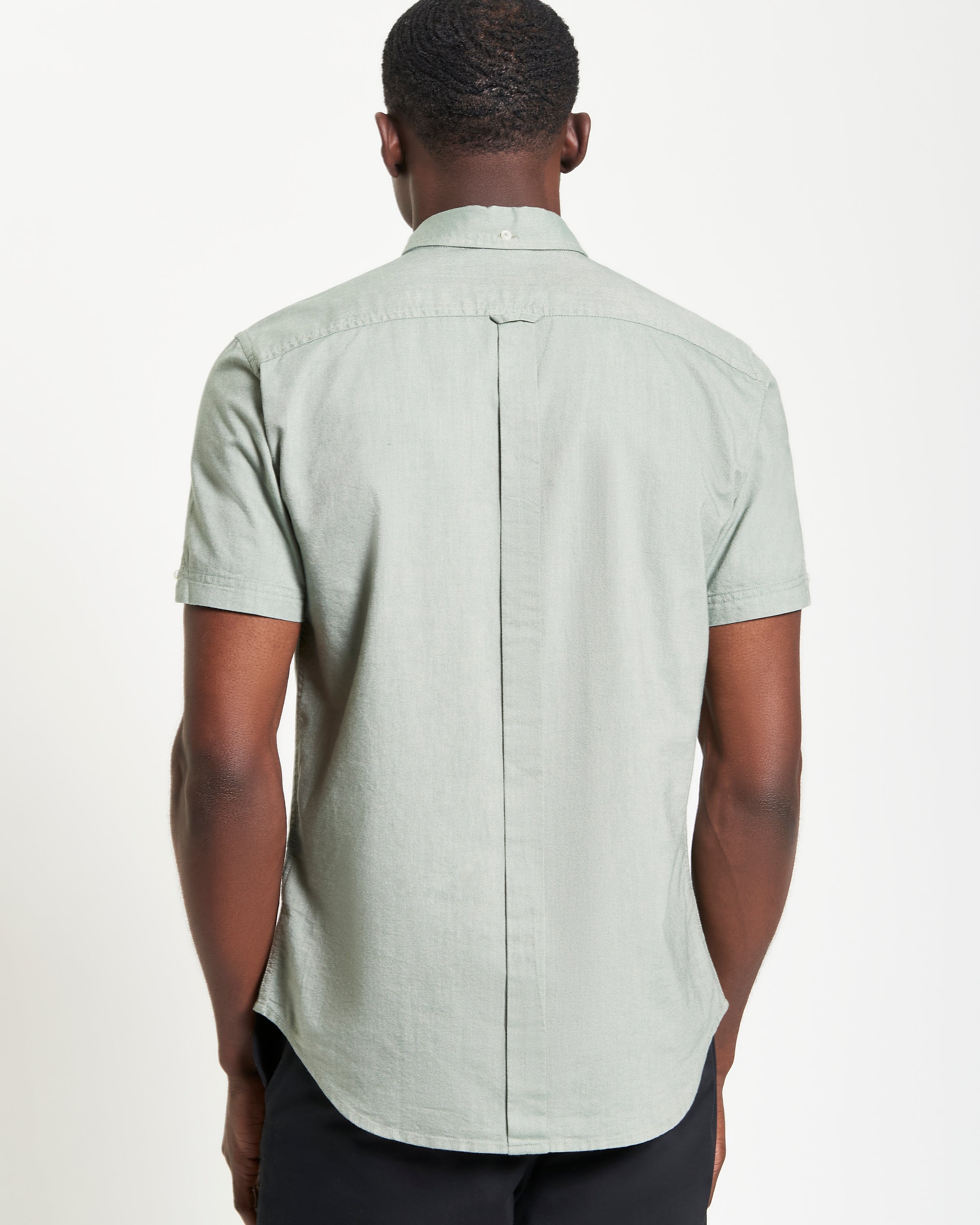 Back view of a man wearing the Signature Oxford Short Sleeve Shirt in light green.