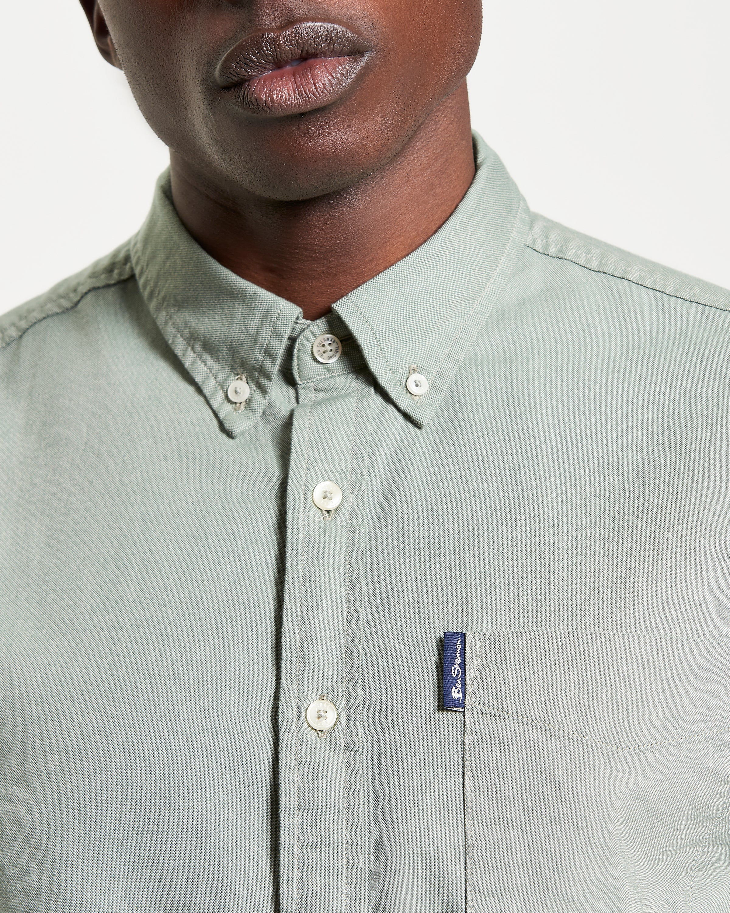 Close-up of a model wearing the Signature Oxford Short Sleeve Shirt with a two-finger button-down collar and chest pocket.