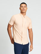 Signature Oxford Short Sleeve Shirt worn by a model, featuring a clean fit and a back pleat, ideal for warm weather.