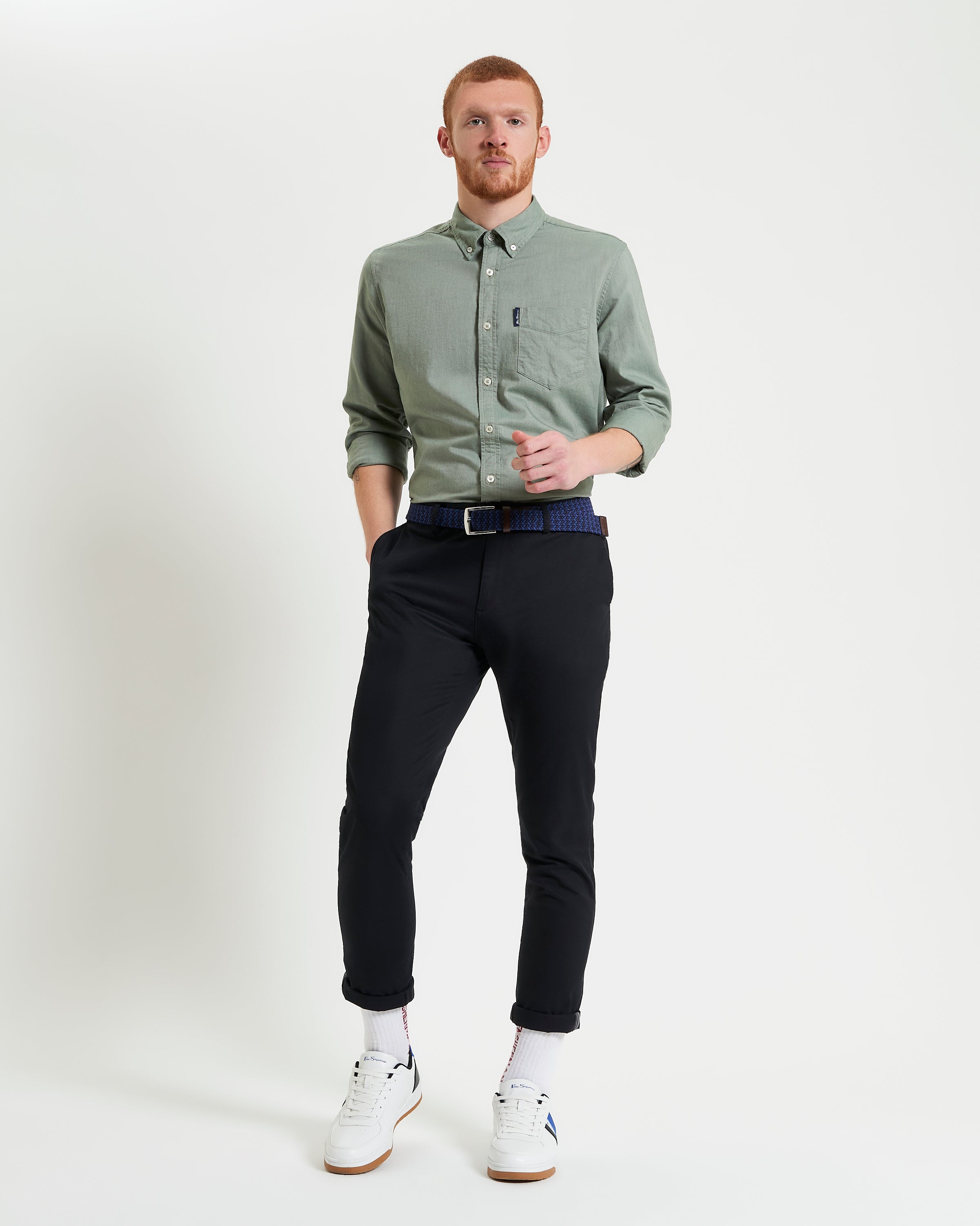 Man wearing a Signature Oxford Long Sleeve Shirt by Ben Sherman, styled with black pants and white sneakers.