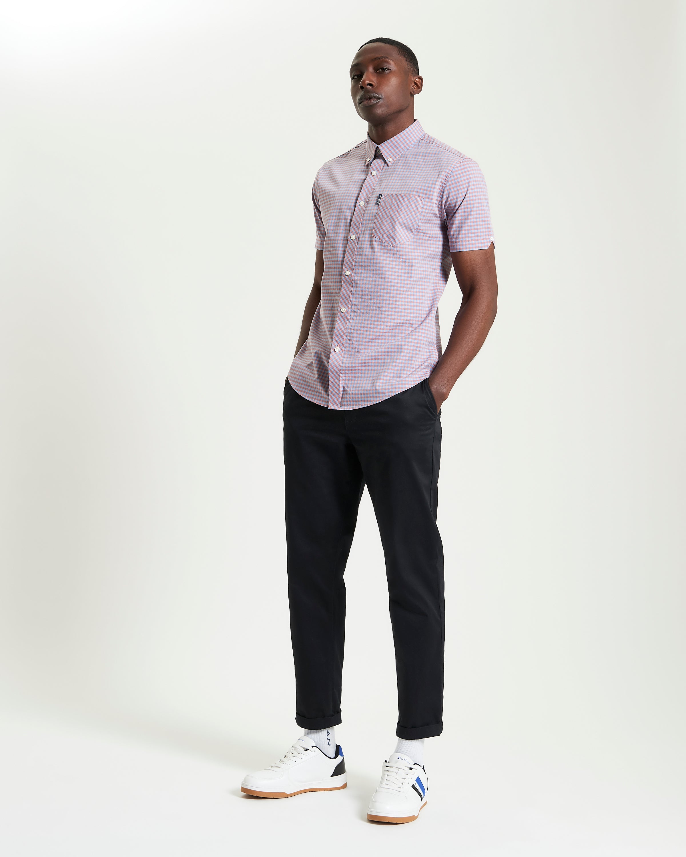 Model wearing Signature Gingham Short Sleeve Shirt with black pants and sneakers.