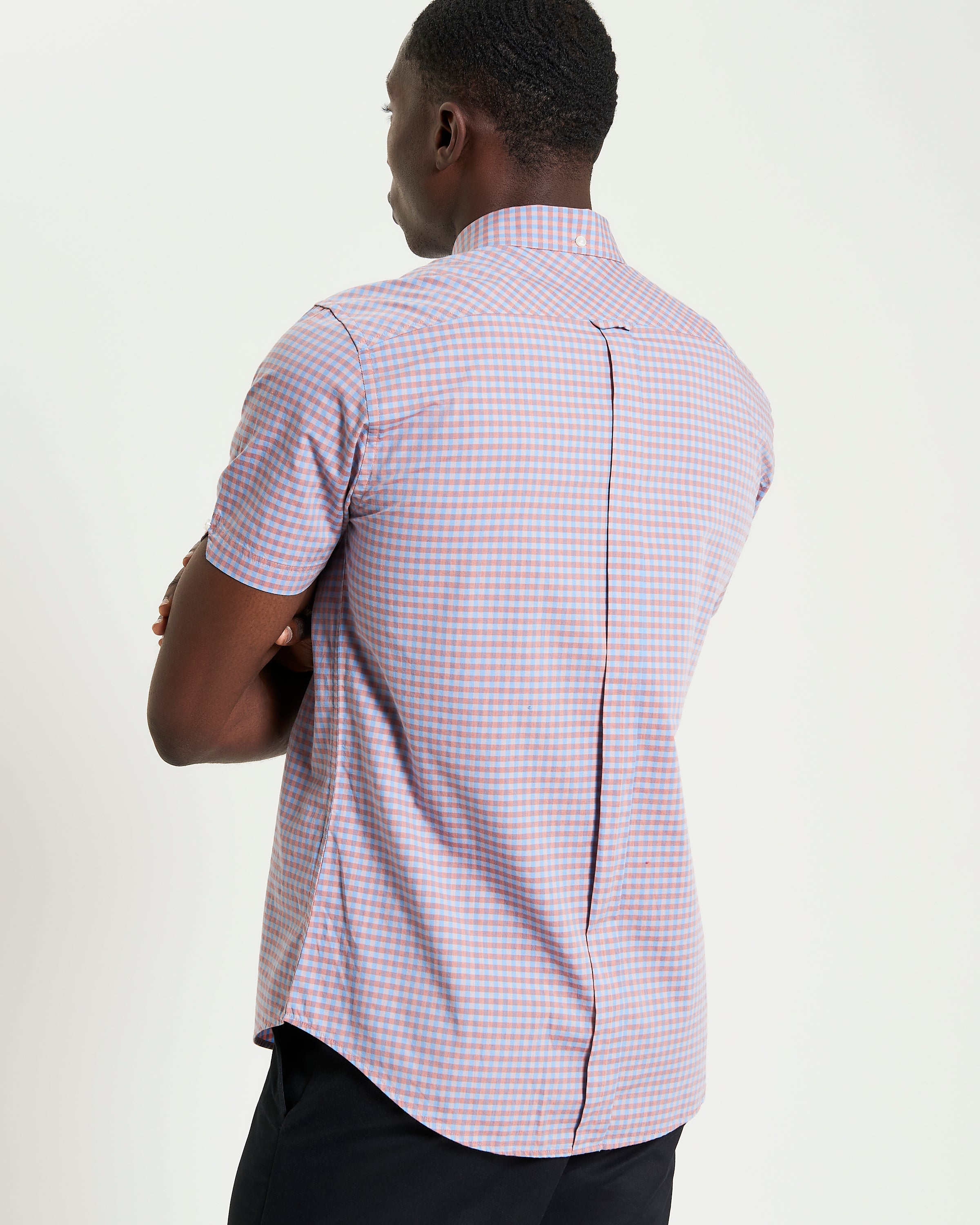 Man wearing a Signature Gingham Short Sleeve Shirt with a two-finger button-down collar and back box pleat for comfort.