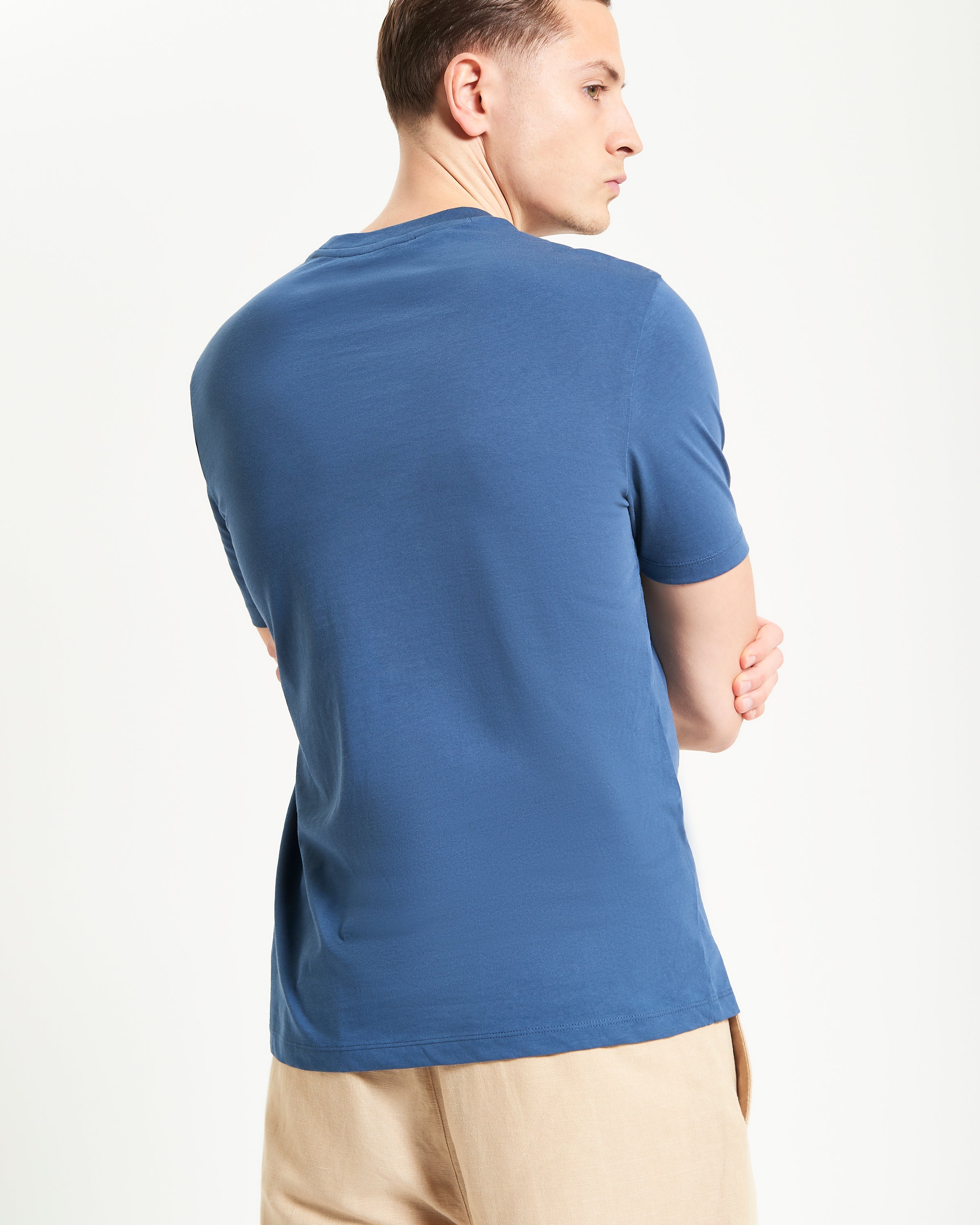 Core Striped Tee – Back view of model wearing a blue organic cotton t-shirt.