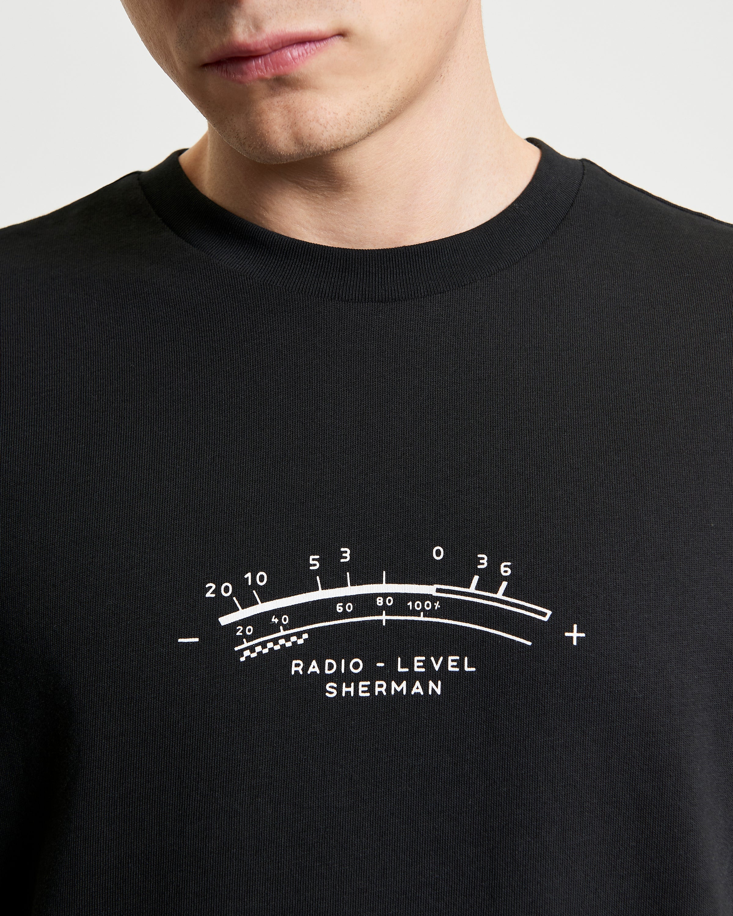 Radio Vibe – black organic cotton t-shirt with pigment chest print featuring radio level design