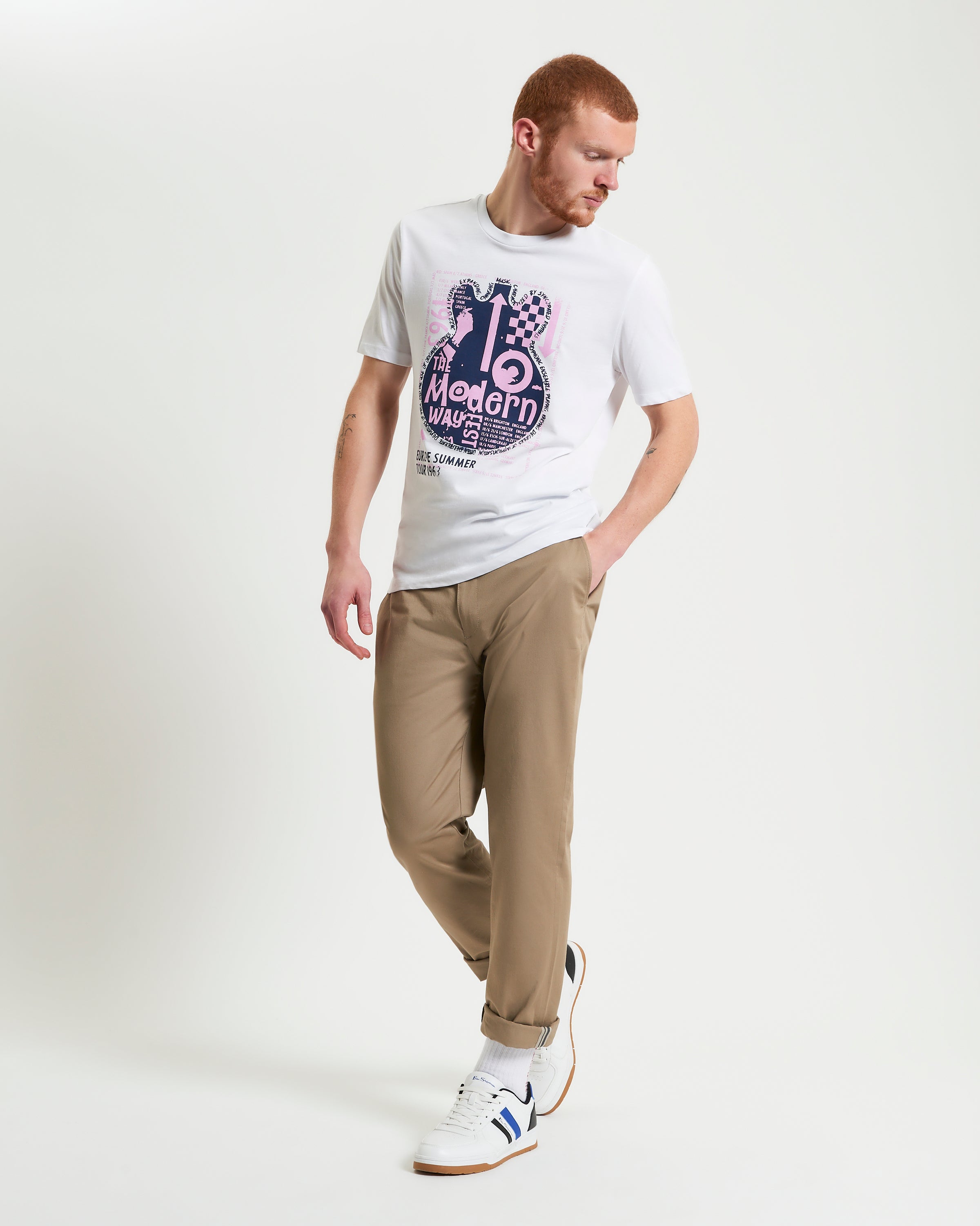 Man wearing Guitar Poster Tee with abstract guitar design, paired with casual pants and sneakers.