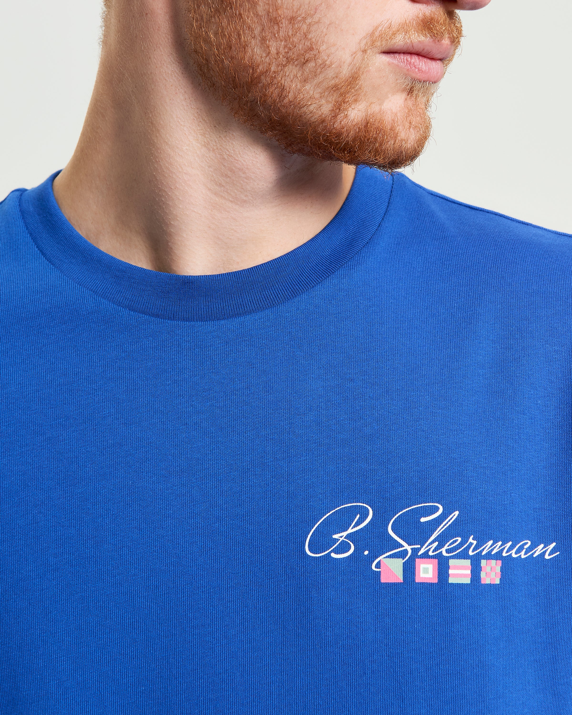Close-up of B Script Back Tee in blue with ‘B. Sherman’ logo printed on the chest.