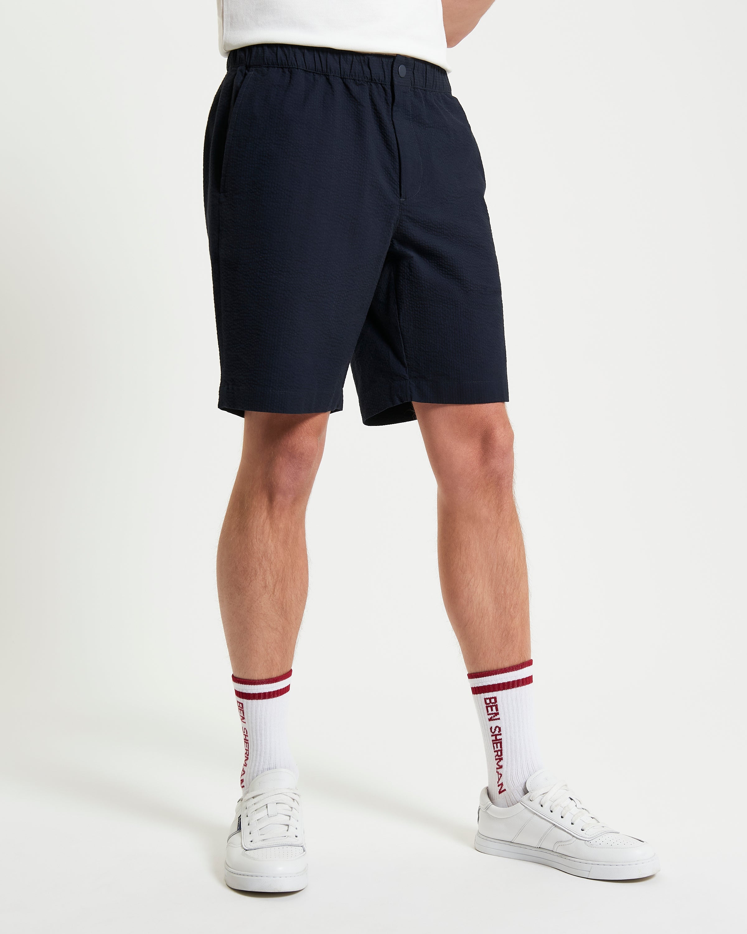 Seersucker Relaxed Short – navy blue shorts with elasticated waistband, featuring a rubberised snap button and zipper closure.
