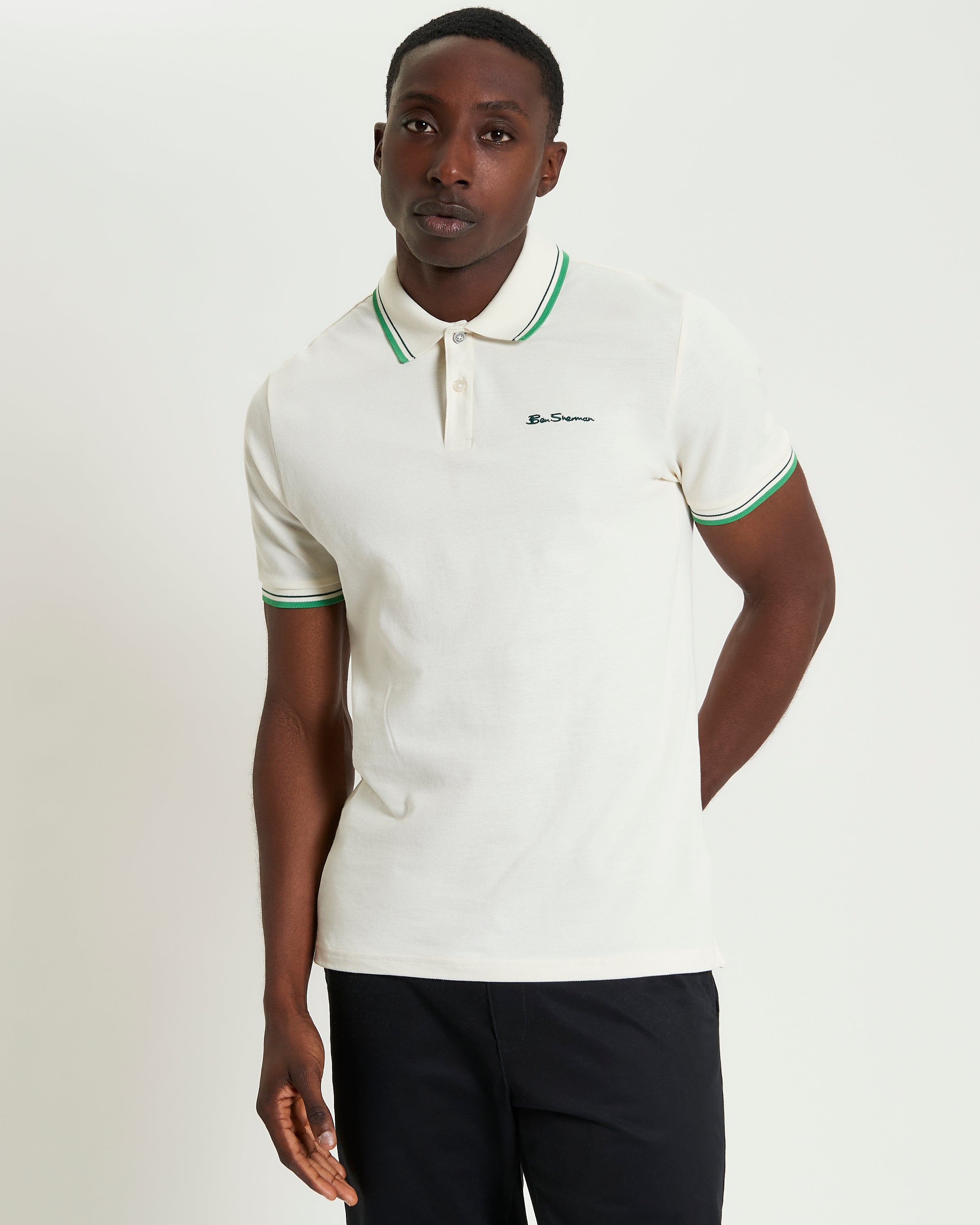 Signature Pique Polo – white polo shirt with green contrast detailing, model wearing a regular fit, refined style.