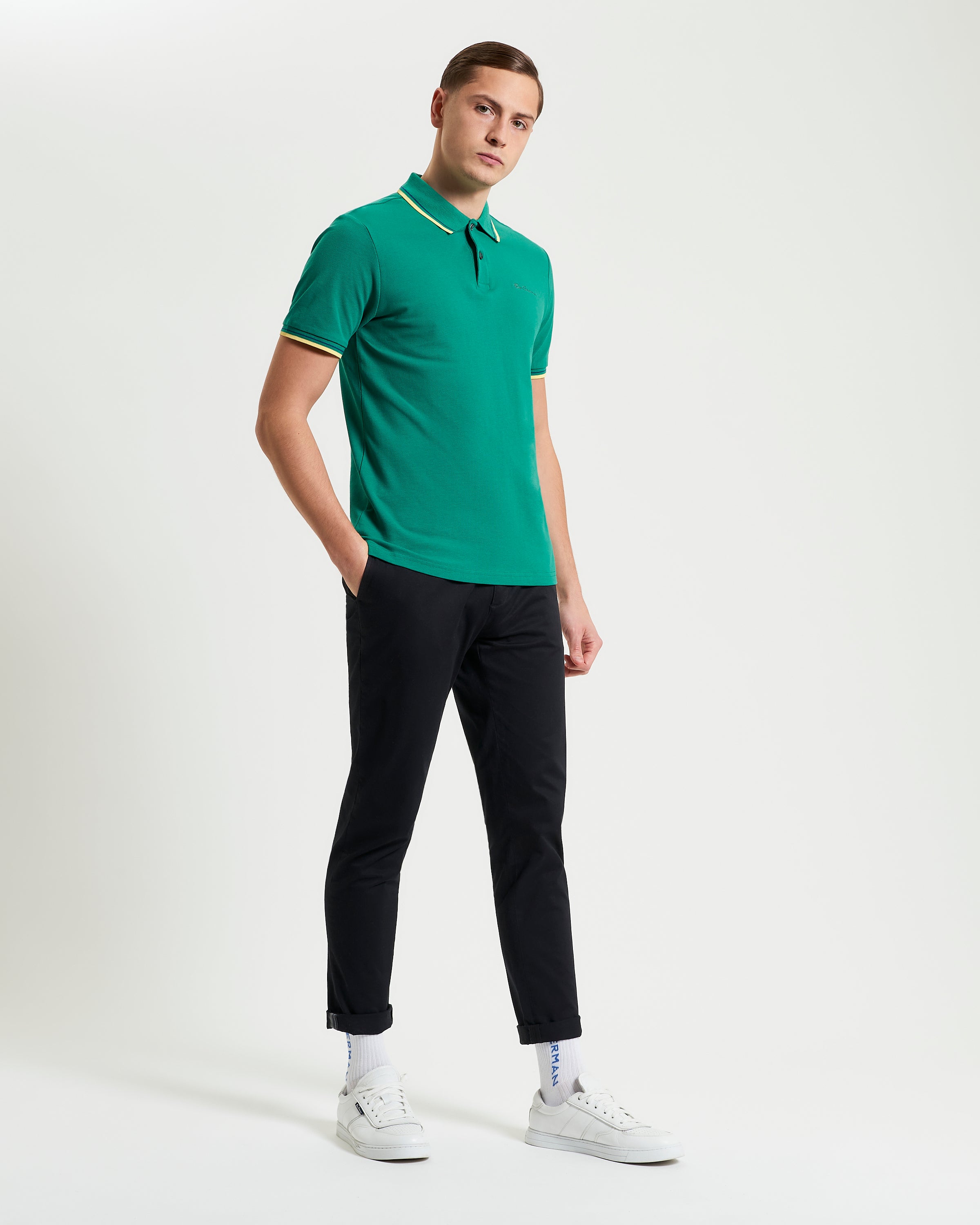Signature Pique Polo – Green. Model wearing a green polo with contrast detailing and trousers.