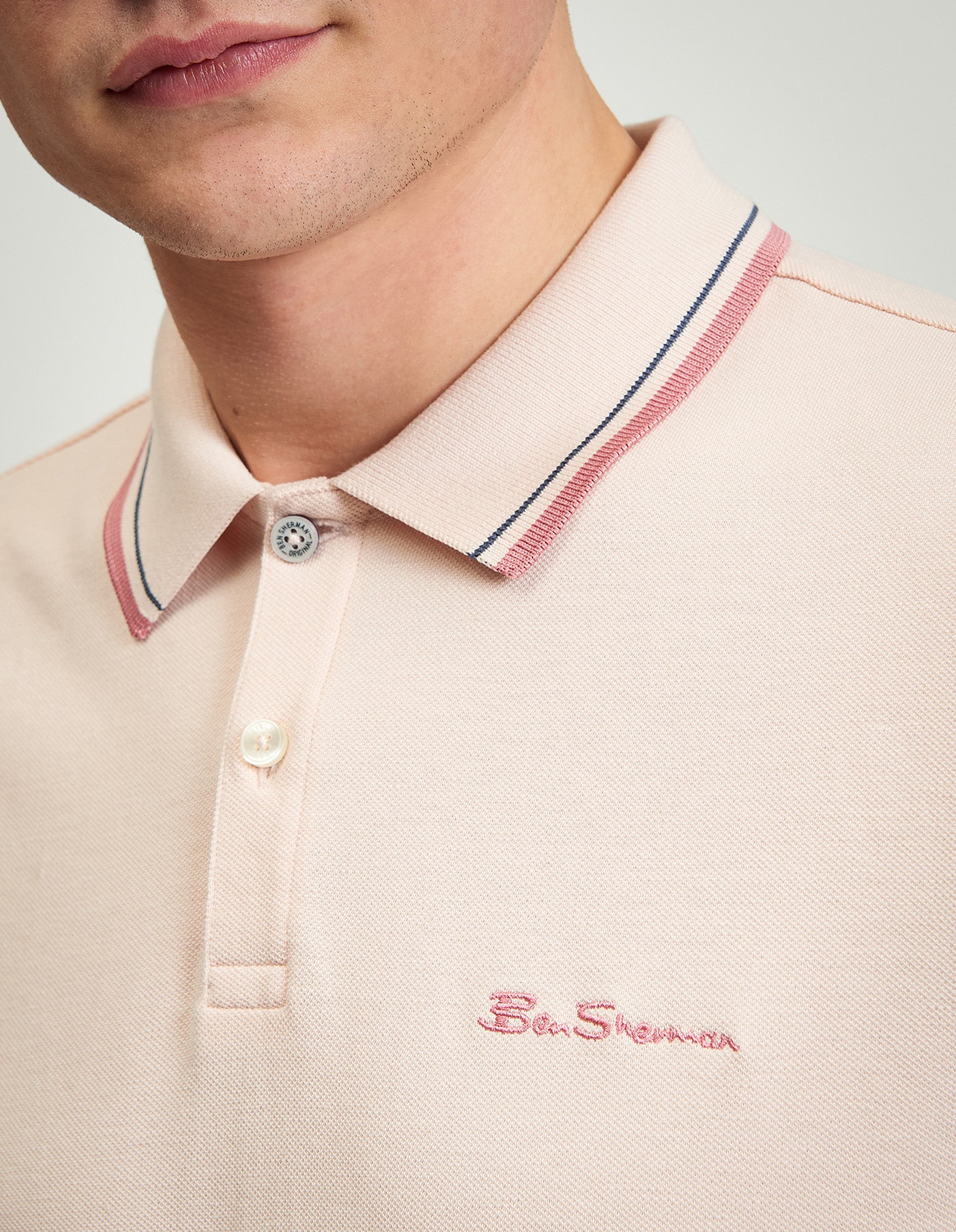 Close-up of a man's neck and collar wearing the Signature Pique Polo with contrast detailing.