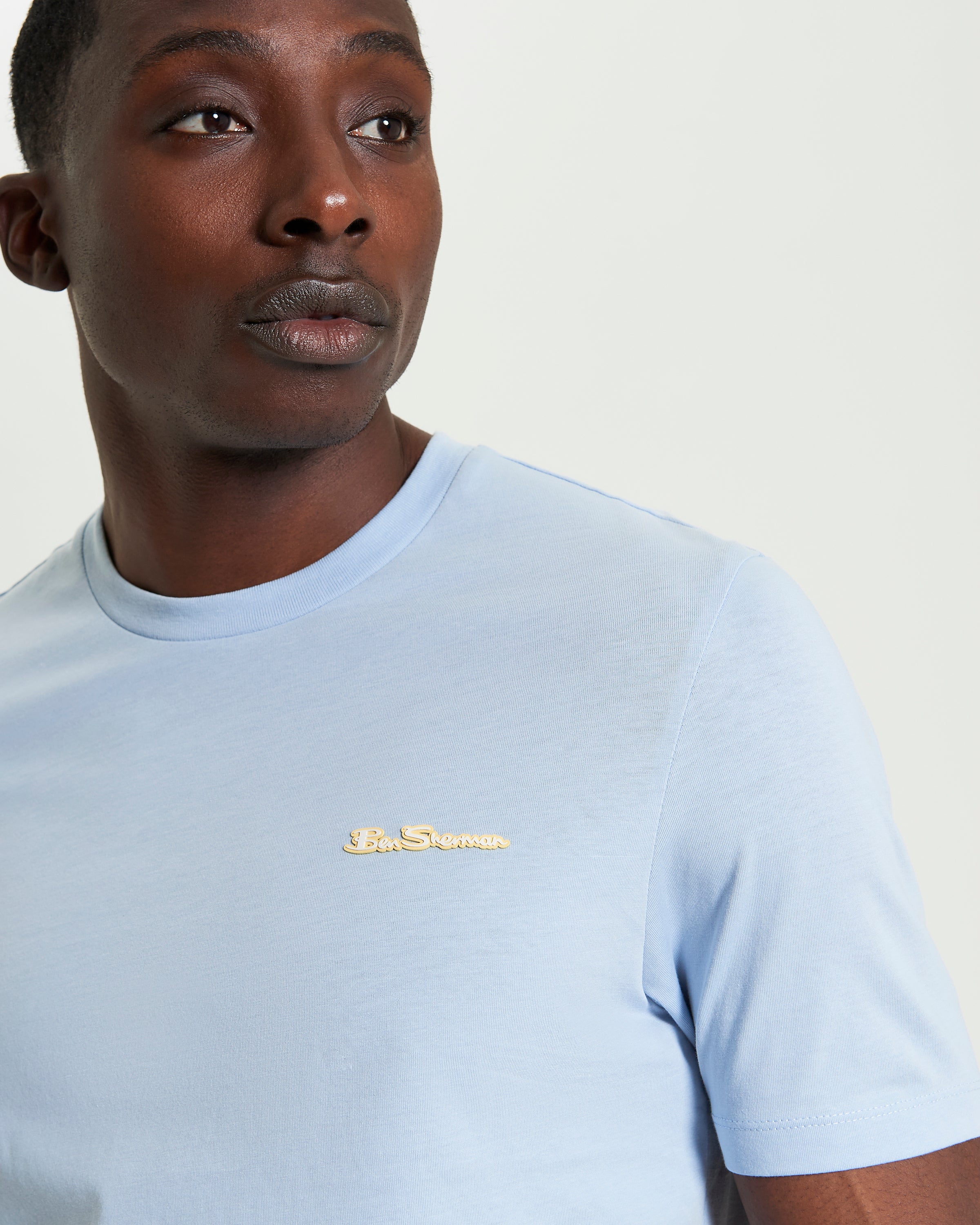 Signature Tee – light blue crew neck with branded silicon badge on model