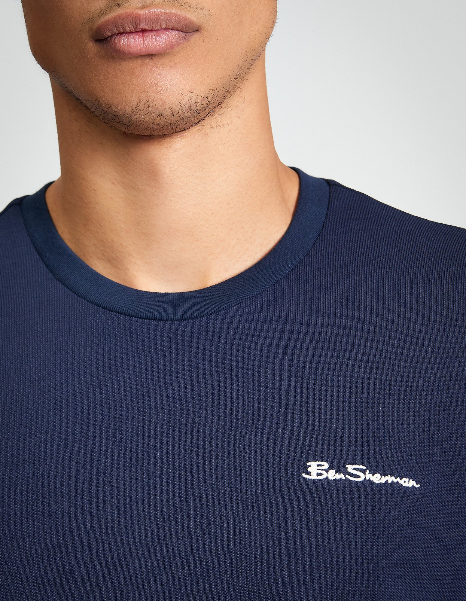 Close-up of the Ben Sherman Pique Tipped Tee showcasing logo detail and navy color.