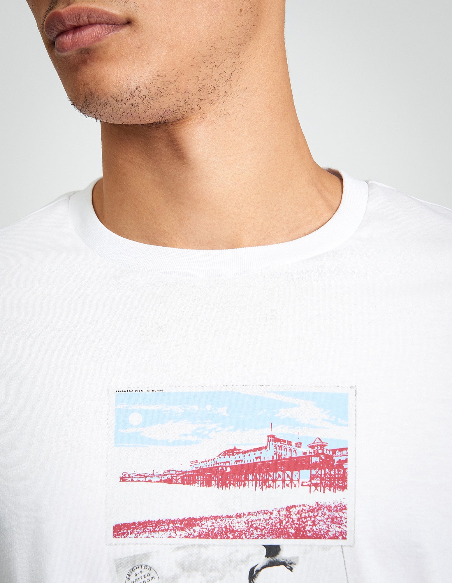 Post Card Tee – featuring a postcard-inspired graphic on a white organic cotton t-shirt, perfect for a casual look.