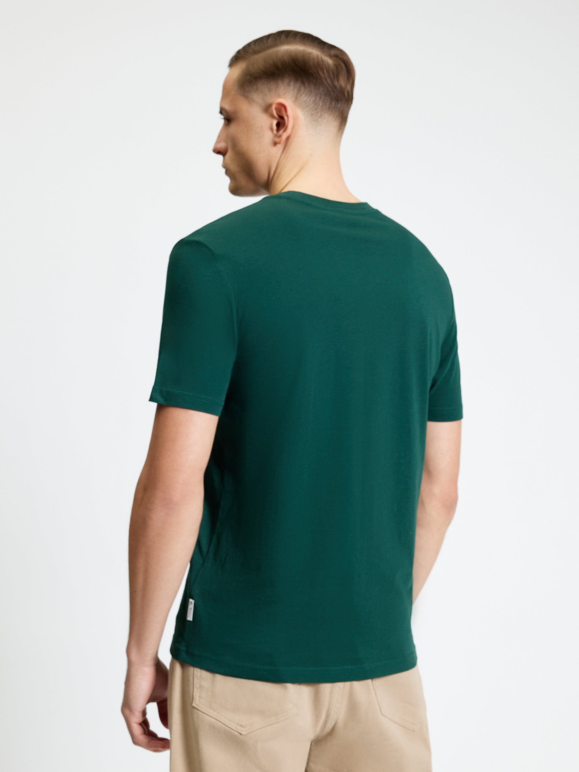 Heritage Club Tee – man wearing a green tee from the back, showcasing its fit and style.