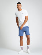 Signature Chino Short – blue shorts paired with a white tee and striped socks for a stylish summer look.