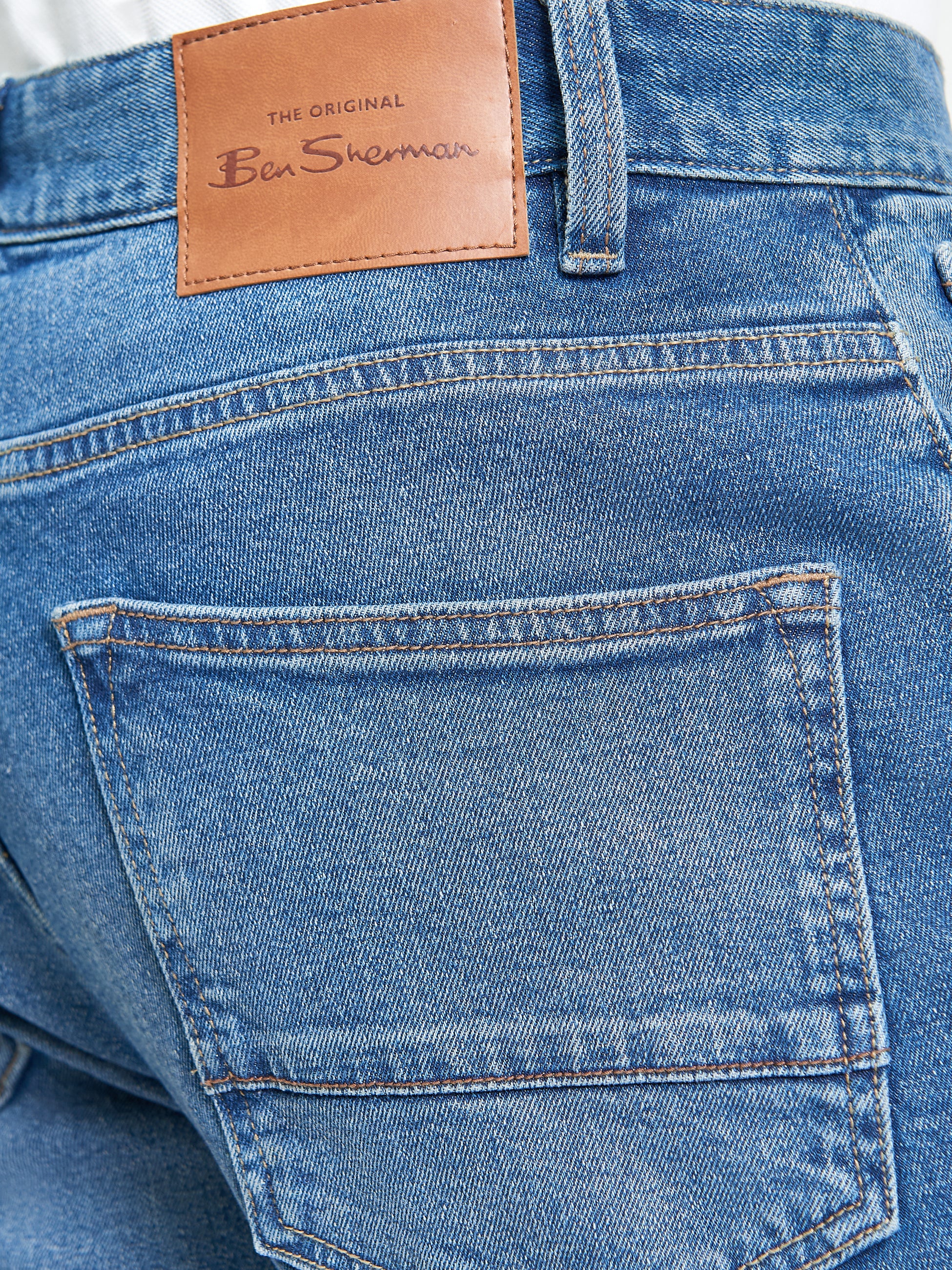 Slim Taper Denim – Back view showing branded patch and classic five-pocket styling.