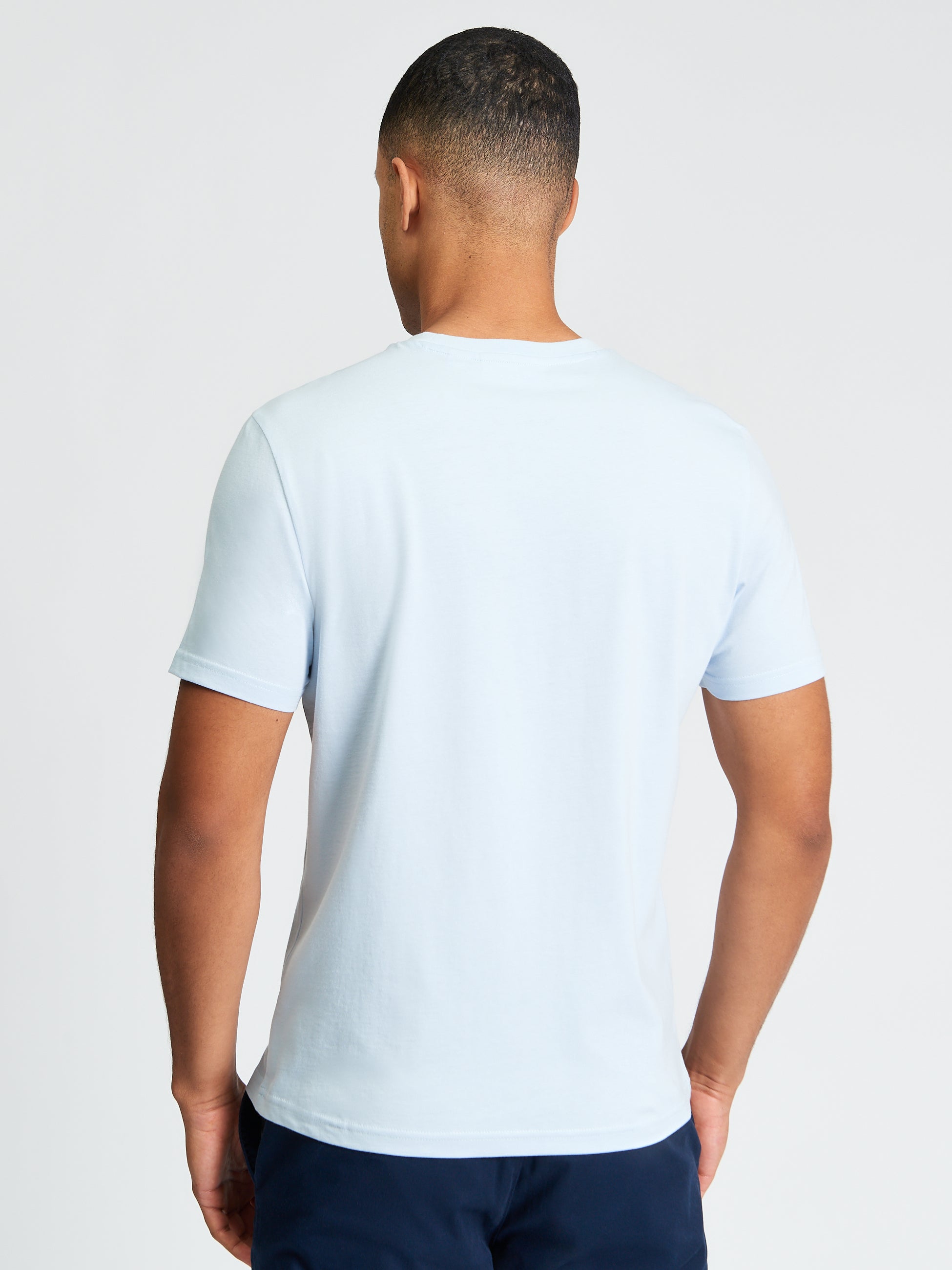 Signature Tee – back view of a man wearing a light blue crew neck t-shirt showcasing premium organic cotton comfort.