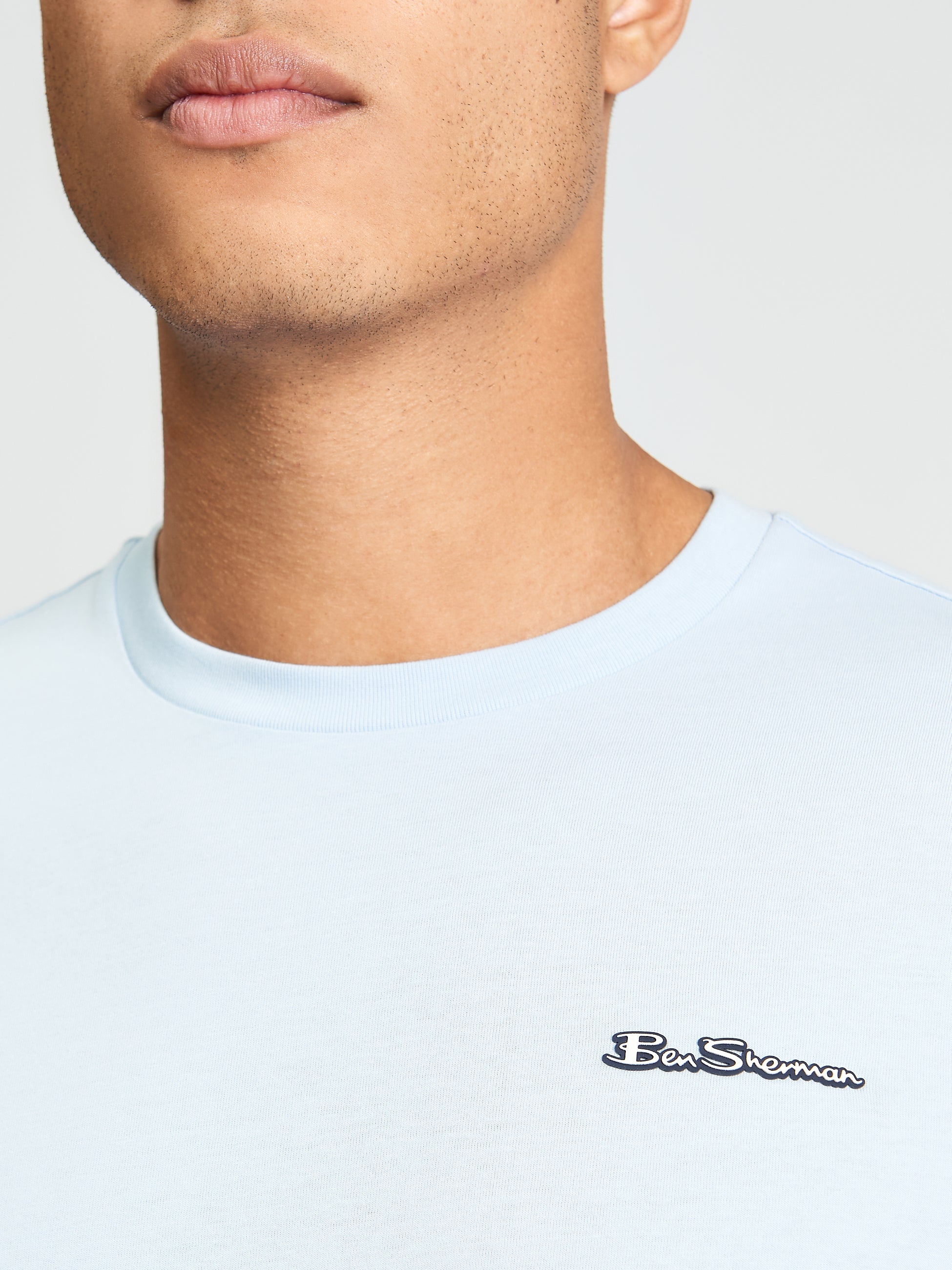 Signature Tee – light blue crew neck with branded silicon badge