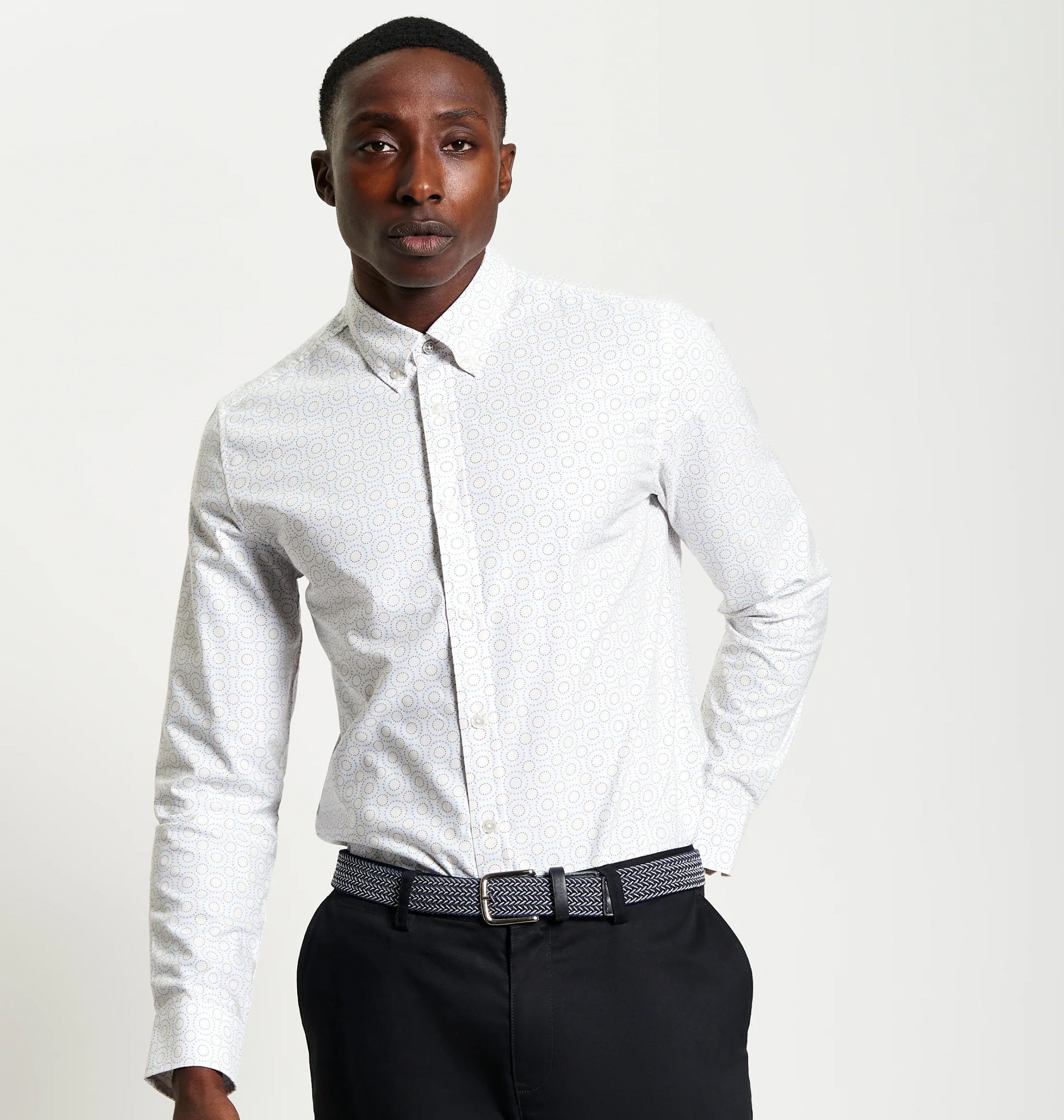 Man wearing Ben Sherman Stipple Spot Print shirt with a patterned tie and black pants on a plain background